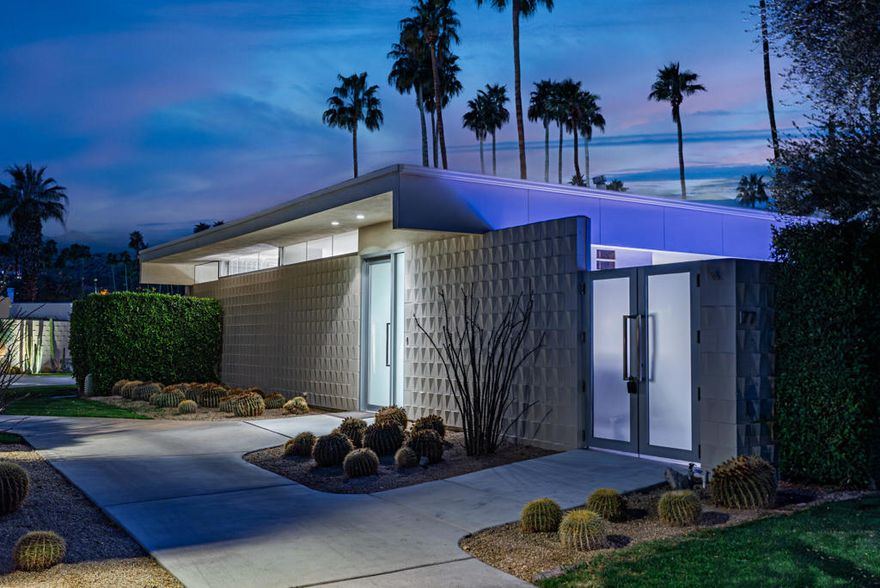 Stunning and sophisticated mid-century modern home in South Palm Springs. Timeless design with modern comforts, featuring sleek quartz countertops, stainless-steel appliances, and polished concrete floors throughout. Walls of glass and 10-ft ceilings capture breathtaking mountain views. Enjoy a cozy double-sided fireplace, remote shades, and updated spa-like baths. Located in the iconic Seven Lakes Country Club with golf, 15 pools, spas, and a clubhouse with restaurant and bar.