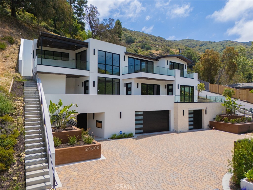 This rare and contemporary 3-story live/work unit at 20000 Laguna Canyon Rd, Unit B, offers 1,388 sq ft of premium space thoughtfully designed for creative professionals, entrepreneurs, and corporate executives. Ideal for artists, designers, architects, or companies seeking upscale corporate housing for executive employees, this loft is located on a scenic corner lot in Laguna Canyon.
Featuring 1 bedroom, 2 full bathrooms, a private workshop, and a dedicated office space, the unit boasts panoramic hillside views from an open patio, elegant black solid cherrywood flooring, sleek glass stair railings, and a fully equipped gourmet kitchen with refrigerator included. Additional conveniences include an in-unit washer and dryer.
The modern building offers a 2,920 sq ft private garage with 5 parking spaces, 1 handicap-accessible stall, 2 motorcycle spots, and EV charging stations. Amenities include an ADA-compliant elevator, ample guest parking, and high-quality finishes throughout.
Just minutes from downtown Laguna Beach, hiking and biking trails, art galleries, and the beach, this exceptional property invites you to live, work, and create in style.
