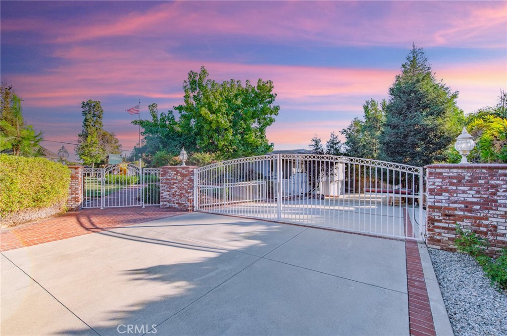 Discover the pinnacle of tranquil California living at this remarkable Friendly Hills estate, where classic elegance meets modern comfort. Nestled on a quiet corner lot, this property is a private sanctuary offering a legacy of quality and peace of mind in one of Whittier's most sought-after neighborhoods.
Step inside to an interior of thoughtful design and luxury. Gleaming hardwood floors flow through formal and informal living and dining areas, perfect for both grand entertaining and casual relaxation. Find a quiet moment in the sophisticated library with its inviting fireplace. The gourmet kitchen is a culinary masterpiece, featuring premium Viking appliances, expansive granite countertops, a large center island, and double ovens. Grand windows and glass doors bathe the home in an abundance of natural light.
The home's accommodations are highlighted by an expansive dual room master suite featuring its own private deck. This luxurious space consists of the main master bedroom, which includes its own retreat and a large walk-in closet, and a magnificent custom bathroom that serves as a personal spa, complete with a classic clawfoot tub, a separate shower, and elegant stone floors. The lower level adds to the home's versatility, featuring a desirable private guest suite with its own separate entry and kitchenette, as well as a large entertainment room perfect for gatherings and recreation.
The exterior is an absolute oasis, your own private paradise. The meticulously manicured grounds create a tranquil, park-like setting offering serene privacy. The backyard is an entertainer's resort, centered around a large, heated swimming pool and separate Jacuzzi. Host memorable gatherings in the private BBQ area or find tranquility under the charming, lighted gazebo. As evening falls, gather on the stunning observation deck.
Perfectly situated, this home offers a rare combination of secluded tranquility and exceptional convenience. You're just moments from the shopping and dining at The Whittwood Town Center, the recreational offerings of the Friendly Hills Country Club, and the natural splendor of Turnbull Canyon's hiking trails. Daily living is effortless with premier supermarkets like Trader Joe's and Ralphs nearby, along with the celebrated restaurants of historic Uptown Whittier, all while being tucked away from the noise of main thoroughfares.
