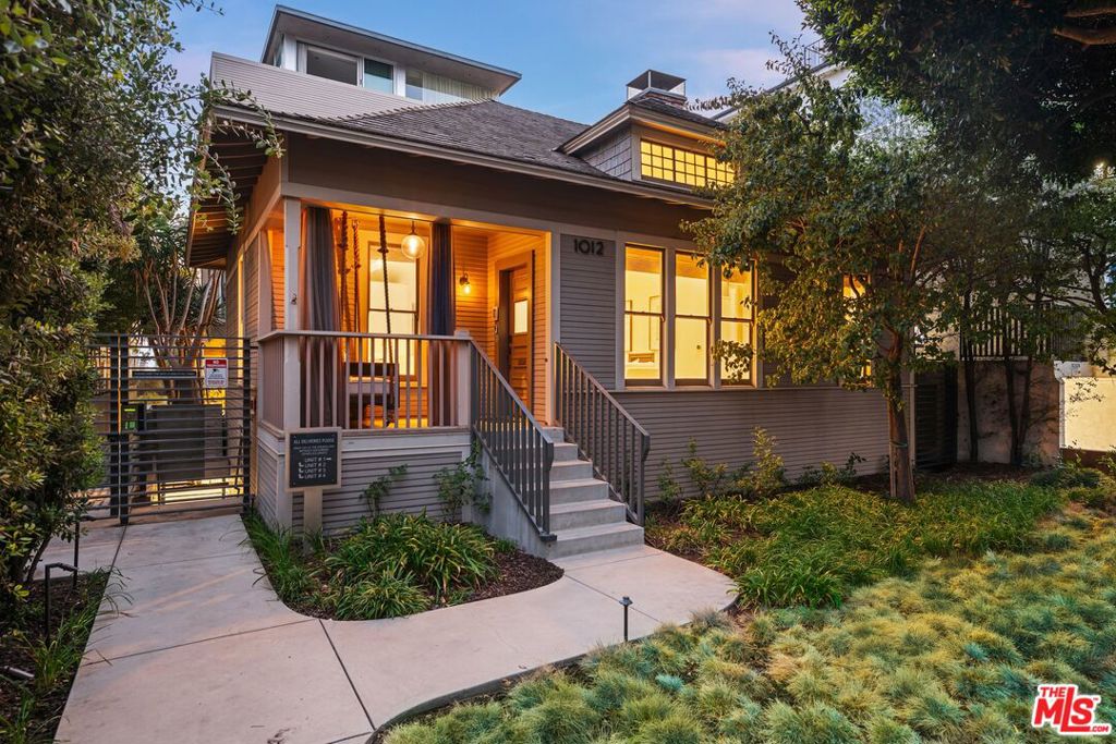 Just steps from the ocean, this SoCal Beach abode is tucked within a charming Craftsman style architecture and was meticulously updated in 2016 from top to bottom, to blend timeless character with modern living. Bright, airy interiors feature soaring vaulted ceilings, smart home lighting, integrated security, and high-end finishes throughout. The open-concept main living space is anchored by a cozy fireplace and seamlessly connects to the dining area and kitchen, creating an inviting atmosphere perfect for both everyday living and entertaining. The chef's kitchen is outfitted with quartz countertops, Miele appliances, a built-in water filtration system, and abundant storage. The dining area is spacious and airy, framed by translucent floor-to-ceiling walls of glass that provide both privacy and natural light. The primary suite offers a serene retreat with a reading nook, private patio access, and a spa-inspired en-suite bathroom with dual floating vanities, a soaking tub, a dual-headed shower, and a walk-in closet. Two additional bedrooms with their own bathrooms echo the same level of detail and quality found throughout the home. Rare for the neighborhood, the residence boasts multiple private outdoor spaces, including a large patio off the primary suite ideal for year-round lounging or entertaining, as well as an intimate terrace off the home office nook. Two secure garage parking spaces with EV charging access add everyday convenience. With Palisades Park, the beach, Montana Avenue, and an array of shops and restaurants just a short stroll away, this home embodies the coveted Santa Monica lifestyle.