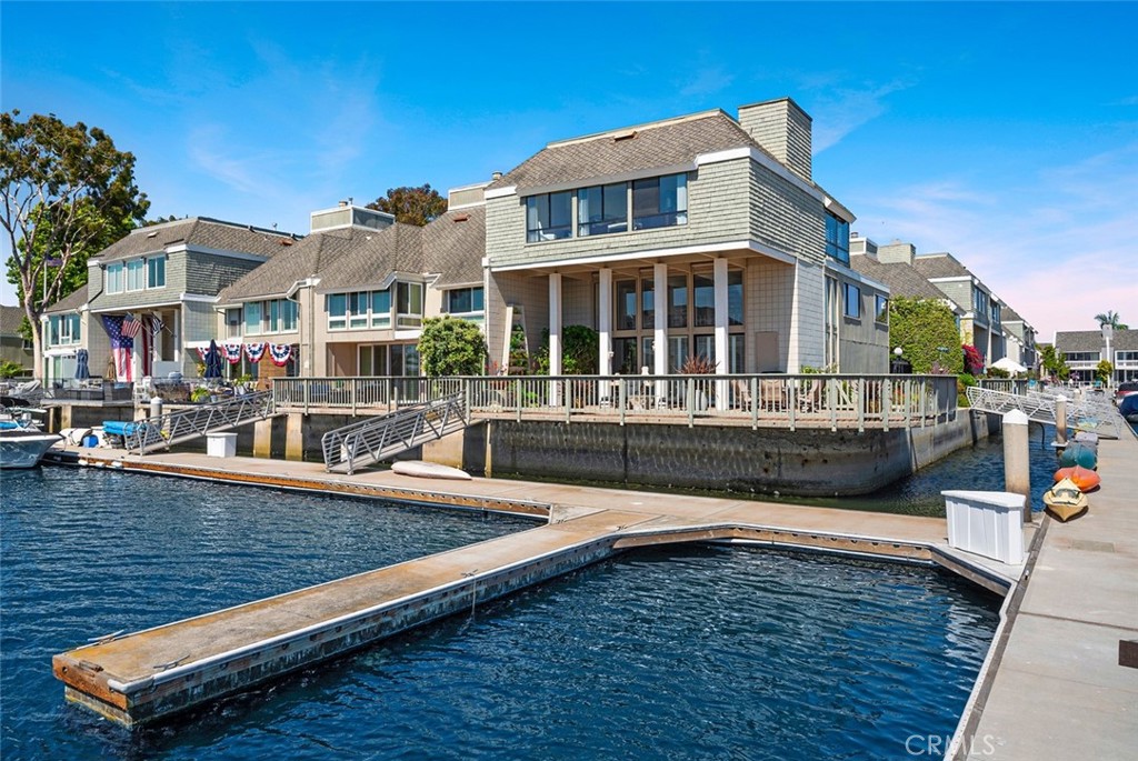 Outstanding Coastal Retreat with dock for a 48-foot boat in gated Tennis Estates in Huntington Harbor. This one-of-a-kind, totally renovated home sits directly on the water on a stunning corner promontory with Bay views from every room. The bright and airy entry-level features a living room with a fireplace, ultra-high ceilings, and floor-to-ceiling windows, plus a cozy den with bar seating. Outside, the cantilevered patio is super-sized with panoramic views of Christiana Bay, the largest bay in the Harbor. The 2nd level showcases a chef’s gourmet kitchen with marble counters and top-of-the-line appliances, and an adjacent formal dining room. The 3rd level provides two ensuite bedrooms and a sitting room with gorgeous views that could be enclosed as a third bedroom. The primary bedroom features two walk-in closets and an ultra-luxurious spa-quality bath. The Tennis Estates community offers shaded walking paths, multiple tennis/pickleball courts, and a beautiful pool. Don’t miss this amazing home and community!