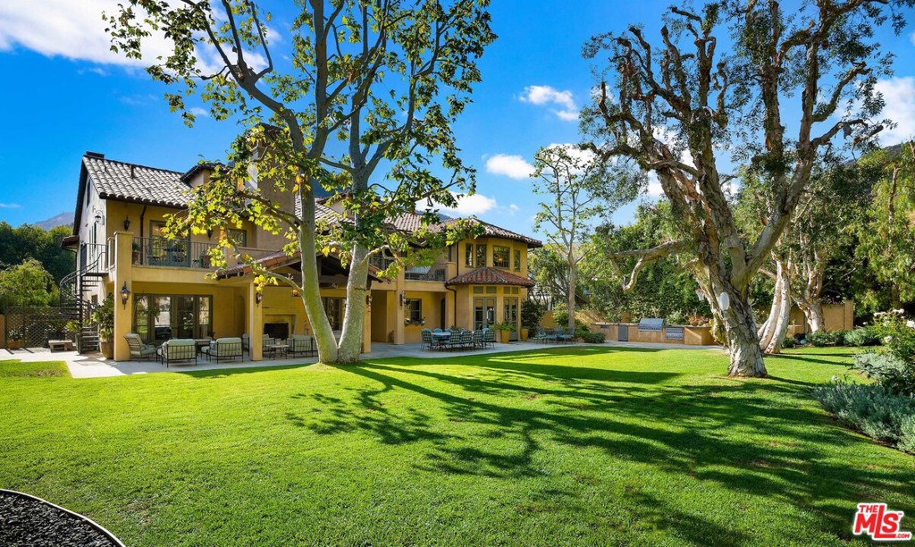 This exquisite Contemporary Mediterranean in the guard-gated Ridgeview Country Estates sits on almost an acre of land and features all of the additional space required for today's new home-centered way of life. The residence boasts two offices, and a full third-floor room currently serving as a home-schooling classroom. The enormous lushly landscaped backyard offers an outdoor loggia with a fireplace, a fully equipped outside kitchen, and an expansive lawn with playground all making socially-distanced gathering with friends and at-home play a breeze. Extensively rebuilt with architectural design by William Hefner and interiors by Kazuko Hoshino, the home features a gourmet kitchen and family room combination, wine room, guest suite with kitchenette, and high-end finishes throughout that include handmade and custom-designed ironwork, mosaic tile, imported stone, and rich wood floors. A three-car garage and large motor court complete this splendid offering.