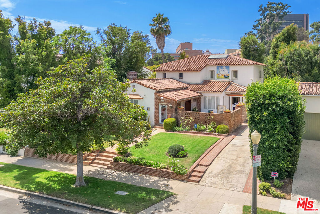 Timeless Mediterranean Elegance in Little Holmby. Nestled on a quiet, picturesque, tree-lined street, this 1930s Mediterranean residence embodies the romance of old-world craftsmanship infused with sophisticated European flair. With 5 bedrooms, 6 baths, and over 3,600 sq. ft., it is a rare offering in one of Los Angeles' most sought-after enclaves, moments from UCLA, Holmby Park, Beverly Hills, and the acclaimed Warner Avenue School. From the very first step inside, the home enchants with its warmth and detail. A private, enclosed courtyard with French doors leading from both the dining and living rooms sets the stage for effortless indoor/outdoor entertaining. Period craftsmanship is evident throughout, with soaring beamed ceilings, vintage Spanish tiles, rich hardwood floors, intricate crown and coffered moldings, and exquisite hand-painted Italian mosaic murals that elevate the home's artistry, stunningly showcased through several windows in the home. The step-down living room, anchored by a grand fireplace beneath exposed beams, exudes character, while the adjacent formal dining room offers timeless elegance for gatherings. The chef's kitchen combines function and charm, complete with stainless steel appliances, granite countertops, multiple prep areas, and a wine cooler. Additional living spaces include a wood-paneled study, a game room, and a refined den...all oriented toward the home's exquisite exterior details and natural light. The lower level includes two bedrooms, one a generous mini-primary with vintage-tiled bath, the other a cozy en-suite ideal for guests or staff. A sunlit staircase leads to the upper level, where the primary suite reveals its own fireplace, voluminous walk-in closet, spa-inspired bath, and a covered balcony overlooking serene treetops...a perfect way to start any day. A secondary upstairs en-suite bedroom completes the private wing. The hallway has an incredible bookcase to house all your favorite classics. At the rear, a large, tiled patio invites al fresco dining and festive gatherings, surrounded by unique tile artistry. The converted garage/guest house, complete with bath, serves as a versatile space for guests or as a home office, with ADU approval in process. This home is more than a residence it is a piece of architectural history. Beyond its enduring beauty, it offers an unrivaled location near UCLA, Westwood Village, Bel Air, Century City Mall, Beverly Hills, and Holmby Park, combining tranquility with world-class convenience.