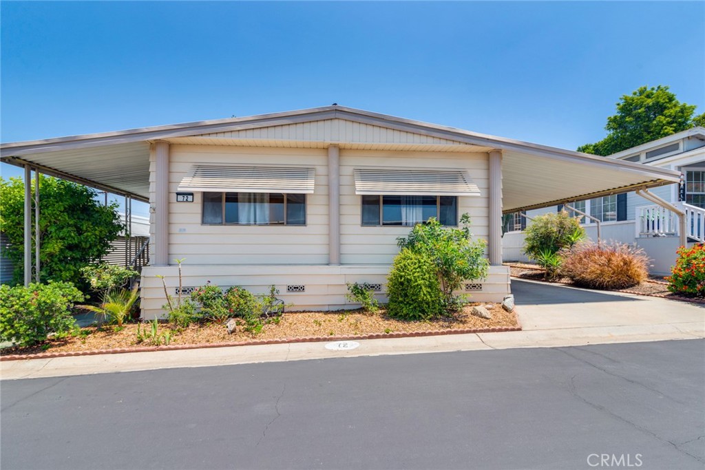 Welcome to this beautiful, well-maintained mobile home in the desirable Villa Magnolia 55+ senior community. The light-filled living room and dining area feature elegant built-in glass display cabinets, perfect for showcasing your favorite décor. Enjoy an open-concept kitchen with a center island, Formica countertops, stainless steel cooktop, refrigerator, and sink, plus a sliding glass door leading to a charming enclosed sunroom — ideal for relaxing or entertaining. Additional highlights include newer flooring, upgraded toilets and a new garbage disposal. Added ceiling fans throughout for year-round comfort. The primary bedroom offers mirrored closet doors and a private en-suite with dual vanities, a walk-in shower, and a soaking tub. The guest bedroom also features a ceiling fan, direct access to the second bathroom, and a walk-in shower. Convenient indoor laundry area adds ease to daily living. Enjoy your morning coffee on the welcoming front porch or in the cozy sunroom. Two car covered carport with a wheelchair ramp, golf cart parking and a mandarin orange tree. Community amenities include RV parking, a refreshing swimming pool, and a commuter-friendly location close to shopping, dining, and freeway access. Don’t miss this opportunity to enjoy comfortable, low-maintenance living in a vibrant 55+ community!