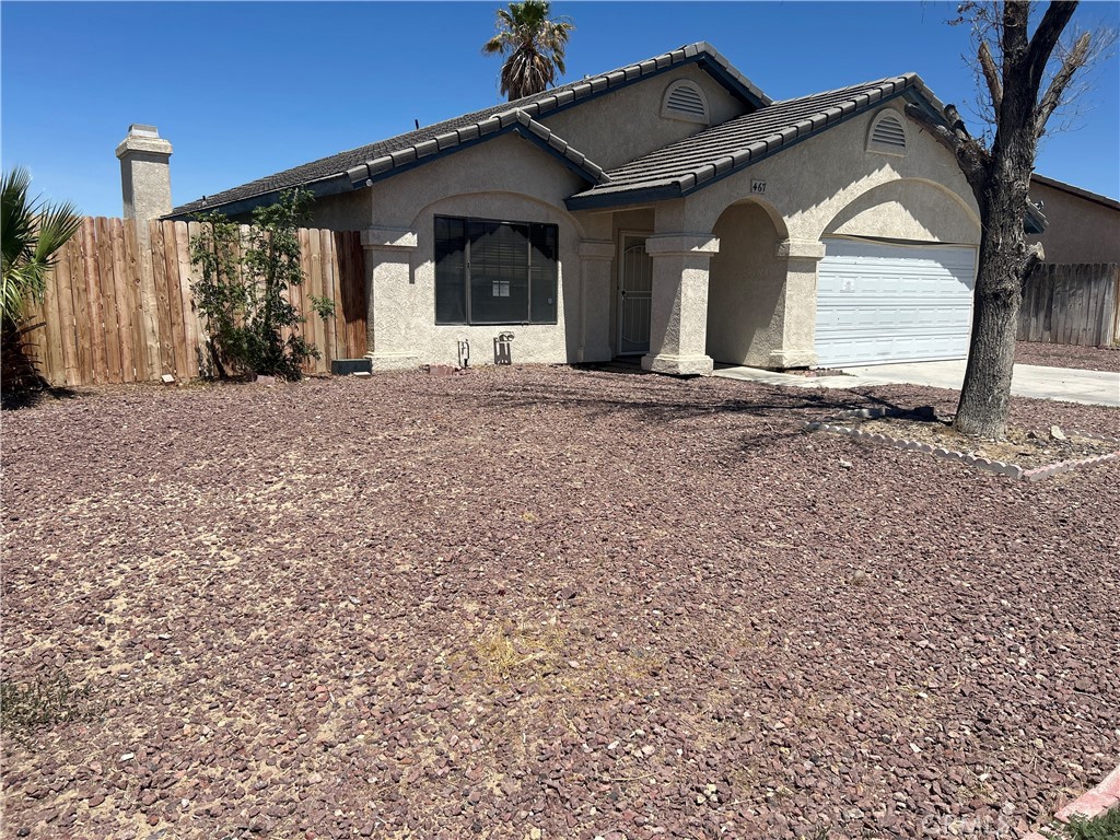 This College Heights home features a lap pool and a covered patio in the backyard, perfect for outdoor relaxation and entertaining. Inside, the open floor plan includes a spacious living room with a fireplace, a dining area, and a kitchen with granite countertops that overlook both the dining area. There's also an indoor laundry room with direct access to the garage. The front yard offers easy-maintenance landscaping with attractive rock scaping.