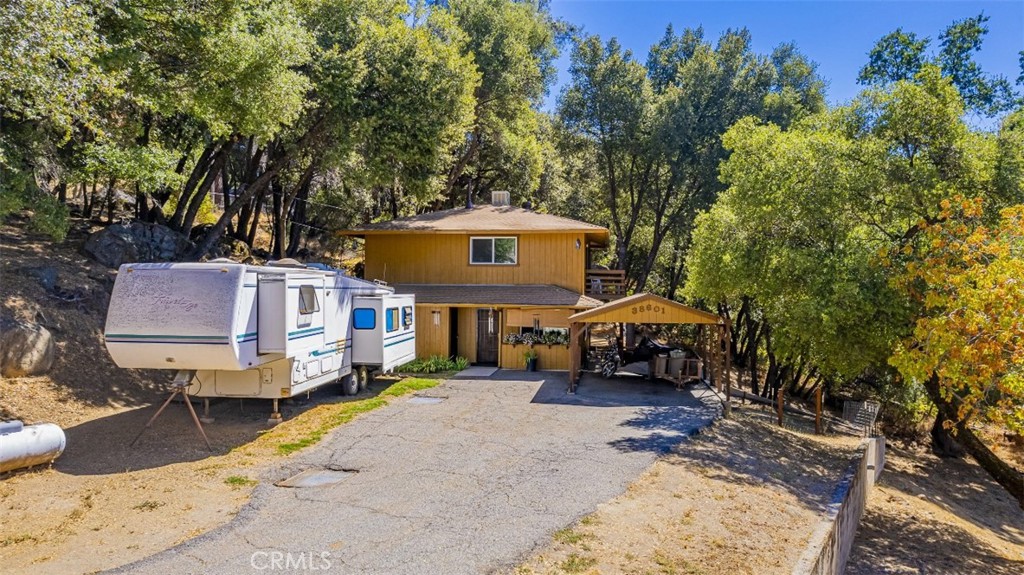 Great retreat home tucked on .82+/- acre among lovely shade trees and unique rock outcroppings! This could be a fabulous starter home or an income earning rental with 2 bedrooms and 1 1/2 bathrooms. Enjoy the peace and quiet on your back porch while relaxing having your breakfast and a storage room off the deck. The feeling of living in the outdoors with beautiful large rock outcroppings amongst the forest, will definitely put your mind to ease. This home is on the smaller side but very cute! Enjoy the warmth of your Pellet stove in the living room on those cooler nights, and the ease to bring in more pellets in the storage room that is right outside the front door and there is a ceiling fan and built-in bookshelves. The dining area and kitchen are full sizes with electric range, dishwasher, range hood, tile counter tops, extra cabinet space and a large walk-in pantry just off the kitchen and laundry room. Newer windows installed throughout the home. The 2 bedrooms and full bathroom are located upstairs, while a smaller 1/2 bath is located downstairs near the laundry room. This property has a convenient location a short drive from downtown Oakhurst and a short drive to beautiful Bass Lake Recreational area. There is a front carport and additional parking space for an RV or additional vehicles that is uncovered. Come and see this house that's great if you want to downsize, use it as a monthly rental or make it your new home! Make sure you enjoy the multiple levels of decks and listen for the birds!