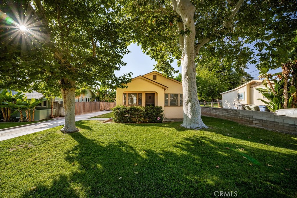 Charming South Redlands home, one block from Olive Ave Market and three blocks from the Redlands Bowl! Built in 1936, this 'Minimal Traditional' single story home with a detached one car garage on a level lot with a private backyard is classic Redlands. You're greeted by mature trees and a front porch. Enter into a comfortable living room with solid surface flooring. The kitchen in the back of the home retains its vintage tile, and there is a small dining area attached. There is also an indoor laundry space off of the kitchen, with additional storage and direct access to the back yard. The two bedrooms are serviced by a full bathroom. The private yard has a sizable lawn, and gated parking. There is central heat and AC, and the electrical panel has been upgraded. Excellent Redlands Schools.