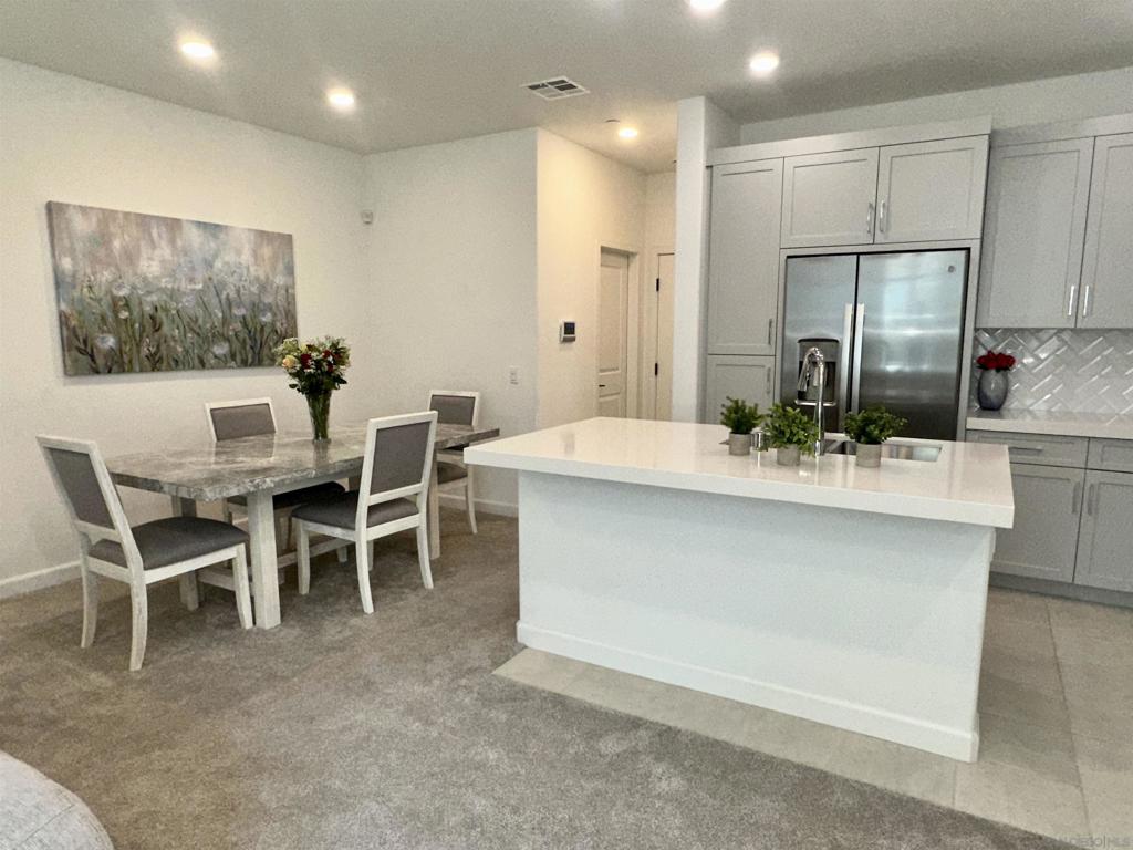 Discover this beautifully maintained 3-bedroom, 2.5-bath townhome located in the sought-after Sunrise Amber community of San Marcos. Set in a resort-style, gated neighborhood, this nearly new two-story home offers a perfect blend of comfort, style, and energy efficiency—with fully owned solar panels, a tankless water heater, and an attached two-car garage. The main level showcases a bright open-concept floor plan ideal for both everyday living and entertaining. The chef’s kitchen features shaker cabinets with soft-close drawers, quartz countertops, stainless steel appliances, and a center island with breakfast bar seating. Continue upstairs to a relaxing primary suite with a sitting area, dual vanities, private water closet, and walk-in closet. Two additional bedrooms also feature walk-in closets and share a modern hall bath. A full-size laundry room with washer and dryer adds extra convenience. New carpet throughout, Electric car charger and alarm system. Community amenities include a sparkling pool and spa, BBQ area, two playgrounds, guest parking, and secure gated access. All just minutes from CSU San Marcos, shopping, dining, and major freeways—this home offers the ideal balance of luxury and location. Don’t miss this incredible opportunity! Lowest priced unit in Amber at Sunrise.