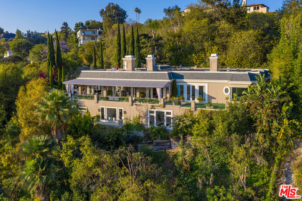 Pristine French Regency-style estate situated on over one acre of lush grounds in prime Lower Bel Air w/sweeping panoramic city views. Encompassing apx. 7,642 sq.ft. of living space, this elegant estate has been impeccably crafted w/exquisite style & fine quality & offers the perfect scale w/high ceilings, generous public rooms & wide hallways throughout. Gated front courtyard w/fountain. The formal living, family & dining rooms sit adjacent to the large chefs kitchen w/oversized island & professional appliances. The exterior space is complete w/covered & open patios, immaculate landscaping, formal gardens, lawn & pool w/surrounding terrace. The master suite features a fireplace, private patio, dual walk-in closets & sumptuous bath. There are 4 addl bdrms & the lower level is complete w/media rm, second kitchen, gym, sauna & wine rm. Elevator. The incredible rooftop deck w/BBQ offers great space for entertaining & relaxing while enjoying the magnificent shimmering city views beyond.