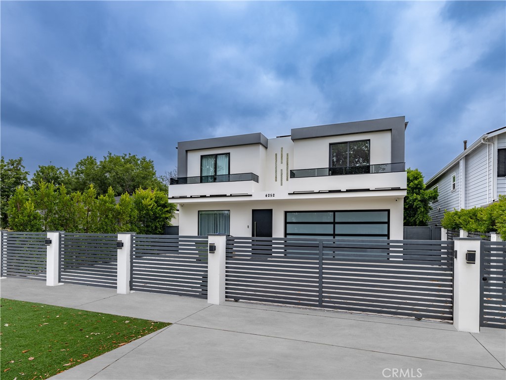 A rare opportunity to lease a gated, newly constructed modern estate in the heart of Studio City. This striking architectural residence offers five en-suite bedrooms, five and a half bathrooms, and over 3,700 square feet of thoughtfully designed living space. From the moment you step inside, you're welcomed by soaring ceilings, oversized porcelain tile floors, LED-lit architectural detailing, and walls of glass that flood the home with natural light. The expansive open-concept layout flows effortlessly from the elegant living room with a sleek linear fireplace to the showstopping chef's kitchen equipped with quartz waterfall countertops, two-tone high-gloss cabinetry, top-of-the-line integrated appliances, and a massive center island perfect for entertaining. Fleetwood-style glass sliders create seamless indoor-outdoor integration and open to a resort-style backyard sanctuary. Lush privacy hedging surrounds the space, where a sparkling zero-edge pool with Baja shelf, spa, multiple shaded lounge areas, and built-in BBQ create the ultimate setting for relaxation and entertaining. One bedroom suite is conveniently located on the main level, ideal for guests or use as a home office. Upstairs, the luxurious primary suite features a private balcony, spa-like bathroom with freestanding soaking tub, oversized rain shower, and dual vanities, as well as a boutique-style walk-in closet with custom glass cabinetry and center island. Additional highlights include a designer powder room, upstairs laundry room, smart home wiring with surround sound and security cameras, zoned HVAC, and a fully finished two-car garage with frosted glass door and checkerboard flooring. Perfectly positioned on a quiet residential street just moments from Ventura Boulevard's premier shopping, dining, and entertainment, and with easy access to top-rated schools and major studios, this home offers the ultimate blend of modern luxury, comfort, and convenience. Now available for immediate lease.