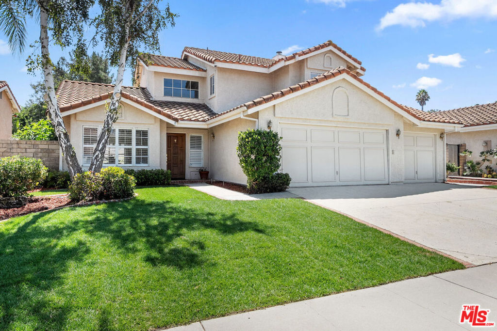 Offers Due Monday 8/25 by 5pm. Discover unparalleled charm in this exquisite Moorpark home, nestled in the desirable Peach Hill community. This home captivates with inviting curb appeal, a spacious 3-car garage, and an open-concept layout designed for modern living. Step through the welcoming entryway into a bright living and dining area, where soaring vaulted ceilings create an airy ambiance. Newly installed luxury wide-plank oak hardwood flooring flows seamlessly throughout, adding warmth and sophistication. The dining area transitions effortlessly into the kitchen, overlooking a cozy family room anchored by a charming brick fireplace. Sliding glass doors lead to an expansive backyard, brimming with potential for a lush lawn, playhouse, or pool (buyer to verify). Entertain in style under the covered patio, perfect for al fresco dining. The main level also features a convenient indoor laundry room and powder room. Ascend the grand, extra-wide staircase, illuminated by a stunning chandelier, to the upper level. The primary suite is a private sanctuary, boasting two closets, a spacious ensuite bathroom with double vanity sinks, soaking tub and shower, and access to an expansive deck overlooking the tranquil backyard. Two additional guest bedrooms and a full bathroom complete the upstairs, offering comfort and versatility. Located minutes from top-rated schools, dining, shopping, and easy freeway access, this home combines convenience with the freedom of no HOA fees.