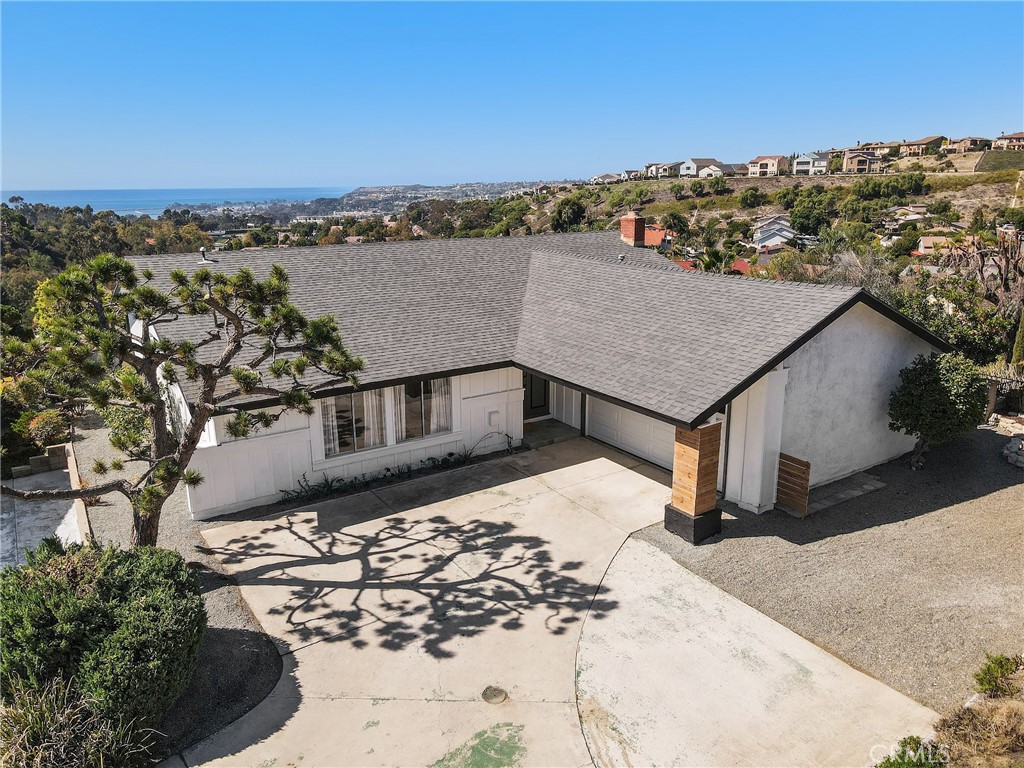 Enjoy sweeping panoramic ocean views and refreshing coastal breezes from this stunning single-story home, perfectly perched above Dana Point Harbor. Nearly every room captures breathtaking water views, setting the stage for coastal living at its finest. Privately tucked away on a quiet cul-de-sac, this 3-bedroom, 2-bath residence blends contemporary style with everyday comfort. The all-white interior, soaring ceilings, wood laminate floors, and newly updated kitchen and bathrooms create a bright and inviting atmosphere. A long, covered patio spans the entire length of the home, extending your living space outdoors—ideal for al fresco dining, entertaining, or even creating an outdoor screening area. Additional highlights include a two-car garage with MyQ app-enabled opener, generous driveway parking, and extra side storage. With easy freeway access and just minutes to downtown Laguna Beach, San Clemente, and historic San Juan Capistrano, this home offers not only modern design but also a truly prime location.