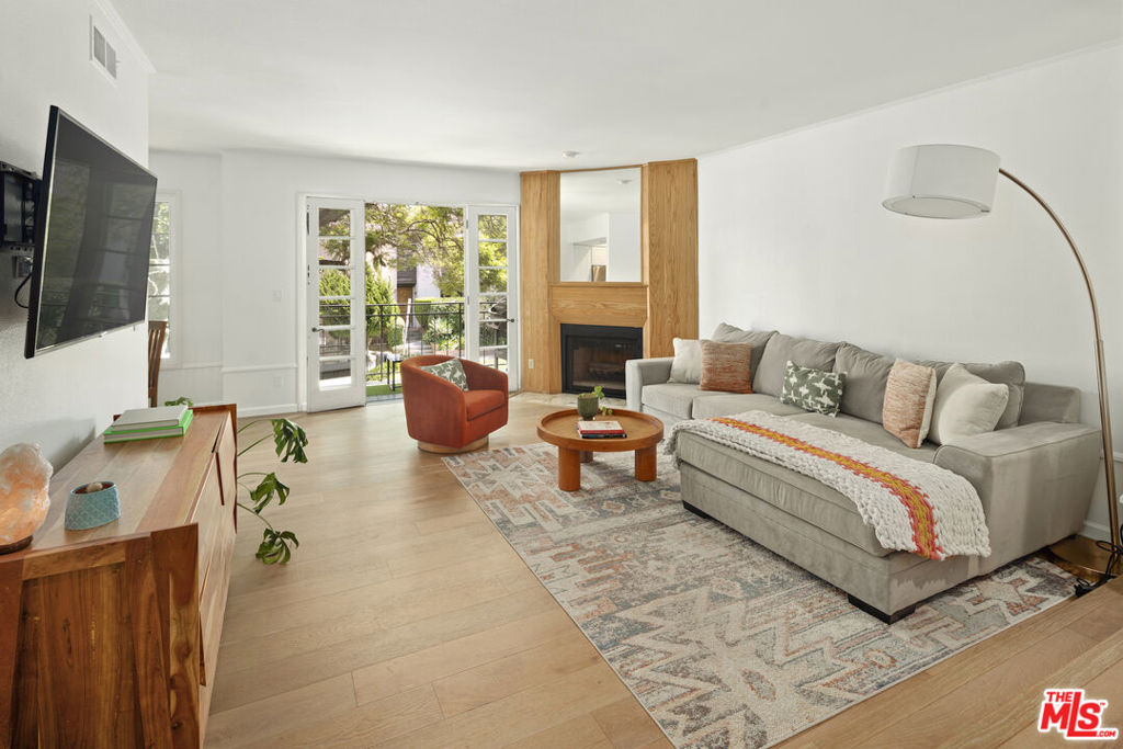 Sophisticated and welcoming, this front-facing contemporary residence combines airy proportions with charming European character. Set above street level, the single-story floor plan spans 1,270 sq.ft. with natural light streaming throughout. The living room opens through elegant French doors to a balcony shaded by mature maple trees, while the adjacent dining area enjoys a leafy street view. The remodeled kitchen features crisp white shaker cabinetry and stainless steel appliances. The spacious primary suite includes double French doors to a private balcony, generous closets, and an ensuite bath with dual vanity. A second bedroom offers flexibility as a guest room or office, served by a full hall bath. Additional highlights include a large laundry room with storage, two tandem garage spaces plus extra storage, and secure guest parking. HOA dues include earthquake Ins, water, trash and basic cable, and internet. Ideally located near Westwood Village, Century City, the new Google campus, and freeway access, this is Westside living at its most effortless.