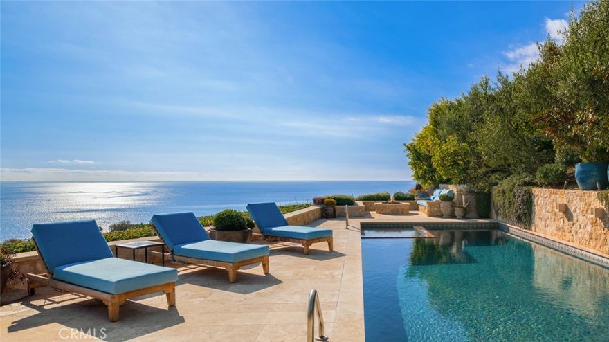 Discover unparalleled luxury in this exquisite French Country-style estate crafted by renowned builder Paul Brant Williger and featured in Luxe Magazine and two HBO productions. Nestled in a prestigious enclave (soon to be part of a gated, fire-wise community) this architectural gem blends breathtaking ocean views over Little Dume, with world-class amenities and impeccable craftsmanship. A stone-arched entryway invites you into a world of sophistication and timeless grandeur, as you are greeted with soaring vaulted ceilings, reclaimed French oak floors, and antique wood beams. The living room is anchored by a French antique wood-burning fireplace that seamlessly connects to the outdoors. The adjacent great room charms with a cozy firewood nook. The chef's kitchen is a culinary masterpiece featuring a sprawling quartzite island, Caesarstone counters, and premium appliances (6-burner Wolf range, Wolf microwave, Miele dual dishwashers, Sub-Zero refrigeration to name a few). The formal dining room captivates with a fireplace, wood-beamed vaulted ceilings, French tiles, and sweeping coastline vistas. A nearby powder room impresses with French tile floors,  floating sink imported from France, and bespoke lighting. The primary suite offers ocean and pool views, a vaulted ceiling, walk-in closets, and fireplace, and sliding doors to the lush backyard. Its spa-inspired ensuite boasts mosaic tile floors, stone counters, double vanity, walk-in shower with a marble bench, and an in-ground soaking tub framed by elegant French windows. A converted garage serves as a versatile office or gym, complete with skylights, and French doors opening to the garden. The laundry room includes built-in storage, washer and dryer, and a wine fridge. The backyard is a private paradise, showcasing panoramic ocean views, a rectangular pool with an integrated hot tub, a fire pit with a custom-built couch, and a tranquil waterfall. A covered outdoor dining area, equipped with infrared heaters and an exterior fireplace, ensures year-round enjoyment. Hand-finished French slip-resistant limestone elegantly paves the yard. Uncompromising craftsmanship defines this estate, from imported antique doors to a handmade Tuscan tile roof. Modern conveniences include ultra-sound-resistant glass windows and sliders, push-button automatic shades, a whole-home generator, three-zone climate control, and a comprehensive security system.