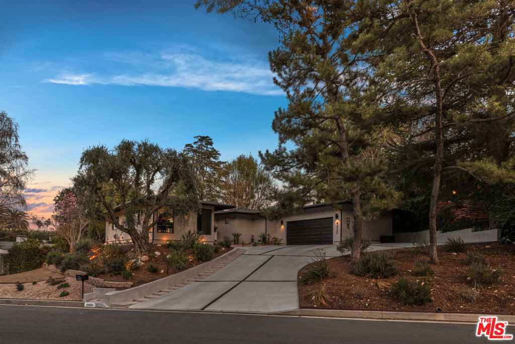 *Loan may be assumable at 2.8% rate for 7 years* Come home to this striking mid-century modern, single-story Woodland Hills home with every high-end amenity desired, situated on more than a half-acre. The property is located on sought after Natoma Ave., where the street ends at the beginning of hiking trails. The home is elevated offering both privacy and stunning unobstructed views of the surrounding hillside, valley, and beyond. Enter through the double doors and be bathed in natural light thanks to the expansive windows and skylights. Discover the open concept living space that radiates harmony and sophistication. The chef's kitchen is thoughtfully designed and boasts high-end appliances, a spacious waterfall island that serves as both a culinary hub and a gathering point, and stylish finishes that make it as functional as it is beautiful. The living and dining rooms plus a custom-built wine bar is a perfect setting to host gatherings or intimate entertaining. The extra-large primary suite is a tranquil haven featuring a walk-in closet and a spa-like bathroom, offering a peaceful escape at the end of the day. The three secondary bedrooms are generously sized, set to be used as bedrooms, fitness center, or office, with each room filled with natural light and stunning views. The showstopper is the expansive backyard accentuating this striking mid-century modern paradise. Step into the resort-like private sanctuary, featuring a shimmering pool, four waterfalls, multiple lounging and gathering areas, multiple vistas, fire pit, bocce court, and beautifully landscaped yard, all combining to create an ideal setting for entertaining, recreation, and relaxation. Come home to the harmonious balance between indoor and outdoor living that provides the canvas for your lifestyle.