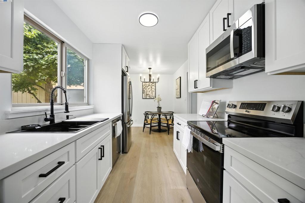 Completely Remodeled private, end-unit Islandia A-Model Townhouse – Turnkey & Stylish Step inside to discover an all-new chef’s kitchen featuring sleek quartz countertops, brand new soft-close cabinets, and a full suite of stainless steel appliances. Both bathrooms have been stylishly remodeled with designer finishes and new tile flooring. Throughout the home, you’ll find luxury vinyl plank flooring, fresh interior paint, recessed lighting, and the complete removal of outdated popcorn ceilings – creating a bright, clean, and contemporary living space. Additional upgrades include new door hardware and fixtures, making this home truly move-in ready. Enjoy the convenience of a spacious 2-car garage, and relax on your private patio just a short stroll from the community pool, scenic lagoon water trail, and ferry terminal – perfect for commuters or weekend explorers. Located in a peaceful, well-maintained community with beautifully landscaped grounds, this home offers both tranquility and convenience.