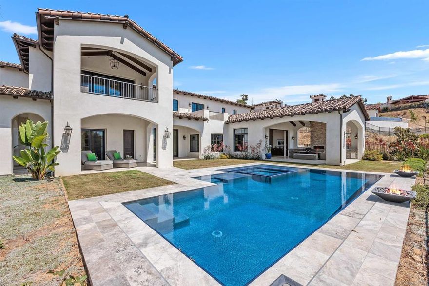 This absolutely stunning custom estate in The Crosby at Rancho Santa Fe was completed in 2022, making it one of the newest homes in this prestigious community! Located within the top-rated Solana Santa Fe (K–8) and Torrey Pines High School districts, near premier private academies. Designed by renowned local architect Scott Grunst, the home is situated on a quiet, beautiful street lined with luxury residences. The 6,523 sq. ft. residence offers timeless elegance and modern luxury. A grand 22-ft foyer welcomes you with soaring arched windows, hardwood floors, exposed solid wood beams, and a dramatic staircase with wrought iron railings. The chef’s kitchen features an eight burner Wolf range with an infrared charbroiler, 64" Electrolux fridge/freezer combo, and double Electrolux dishwashers, while the wet bar has a built-in kegerator. Wine lovers will appreciate the custom, temperature and humidity-controlled 800-bottle wine cellar with additional storage space. The house has Brazilian quartzite countertops and custom-built stained alder wood cabinetry throughout. Enjoy seamless indoor-outdoor living with disappearing pocket sliding doors that open the main living room to a covered loggia with full outdoor kitchen, fireplace, and Wolf BBQ. The resort-style backyard is very private and boasts a rim flow PebbleTec® coated pool, vanishing-edge spa, raised fire pits, and unobstructed sunset views over a protected natural preserve.  The home includes an elegant executive office downstairs with built-in bookcases and a fireplace, a massive upstairs primary suite, and a main-level guest/primary suite—perfect for multigenerational living. Upstairs you will find two additional ensuite bedrooms and a game room on the landing above the living room. Additional highlights include an owned solar system, oversized motor court, and a four-car garage setup: attached two-car garage with Tesla charger and detached two-car garage with added insulation and A/C wiring for yoga, gym, or studio use. The community is a quick 5-minute drive to Rancho Santa Fe Village through the north gate, while the south gate provides easy access to Hwy 56, Hwy 15, and Hwy 5 for convenient commutes, shopping, dining, and beach trips.  Residents enjoy amenities such as a Fred Couples-designed golf course, 35,000 sq. ft. clubhouse, tennis and pickleball courts, Olympic size pool, spa, fitness center, fine dining, and vibrant social events.