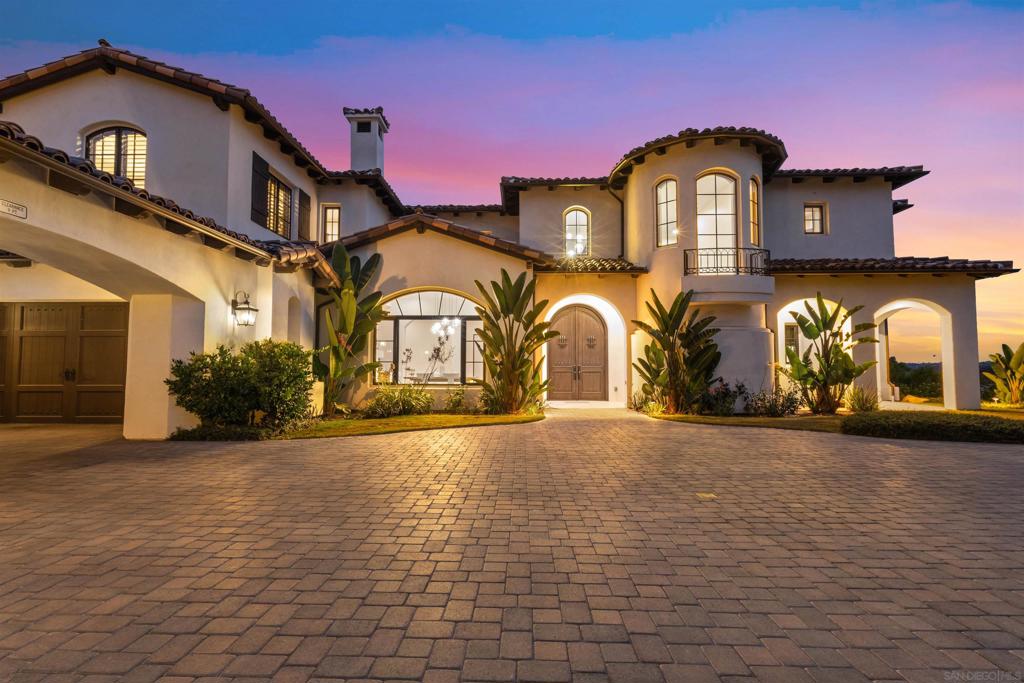 Seller will entertain offers between $5,690,000 and $5,890,000. This absolutely stunning custom estate in The Crosby at Rancho Santa Fe was completed in 2022, making it one of the newest homes in this prestigious community! Located within the top-rated Solana Santa Fe (K–8) and Torrey Pines High School districts, near premier private academies. Designed by renowned local architect Scott Grunst, the home is situated on a quiet, beautiful street lined with luxury residences. The 6,523 sq. ft. residence offers timeless elegance and modern luxury. A grand 22-ft foyer welcomes you with soaring arched windows, hardwood floors, exposed solid wood beams, and a dramatic staircase with wrought iron railings. The chef’s kitchen features an eight burner Wolf range with an infrared charbroiler, 64" Electrolux fridge/freezer combo, and double Electrolux dishwashers, while the wet bar has a built-in kegerator. Wine lovers will appreciate the custom, temperature and humidity-controlled 800-bottle wine cellar with additional storage space. The house has Brazilian quartzite countertops and custom-built stained alder wood cabinetry throughout. Enjoy seamless indoor-outdoor living with disappearing pocket sliding doors that open the main living room to a covered loggia with full outdoor kitchen, fireplace, and Wolf BBQ. The resort-style backyard is very private and boasts a rim flow PebbleTec® coated pool, vanishing-edge spa, raised fire pits, and unobstructed sunset views over a protected natural preserve. The home includes an elegant executive office downstairs with built-in bookcases and a fireplace, a massive upstairs primary suite, and a main-level guest/primary suite—perfect for multigenerational living. Upstairs you will find two additional ensuite bedrooms and a game room on the landing above the living room. Additional highlights include an owned solar system, oversized motor court, and a four-car garage setup: attached two-car garage with Tesla charger and detached two-car garage with added insulation and A/C wiring for yoga, gym, or studio use. The community is a quick 5-minute drive to Rancho Santa Fe Village through the north gate, while the south gate provides easy access to Hwy 56, Hwy 15, and Hwy 5 for convenient commutes, shopping, dining, and beach trips. Residents enjoy amenities such as a Fred Couples-designed golf course, 35,000 sq. ft. clubhouse, tennis and pickleball courts, Olympic size pool, spa, fitness center, fine dining, and vibrant social events.