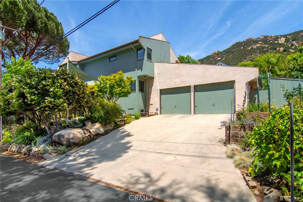 BEST VALUE IN MONTE NIDO! Tucked away on a quiet, neighborly street where everyone still knows each other by name, this mid-century modern retreat in Monte Nido offers architectural charm and serene living. Featuring soaring vaulted ceilings and an open-concept floor plan, the home is filled with natural light and canyon views that bring the outdoors in. The main level includes a bedroom and full bath—ideal for guests, a home office, or multigenerational living. The attached garage offers direct access, and the updated kitchen flows effortlessly into the living and dining areas, perfect for everyday living and entertaining. Upstairs, you’ll find two bedrooms, each with its own en-suite bathroom. The spacious primary suite serves as a calming escape, while the second upstairs bedroom is ideal for a child’s room, guest space, or creative studio. Outside, the low-maintenance backyard is perfect for al fresco dining, lounging, or light gardening. Monte Nido is a truly special enclave—cooler than the rest of the San Fernando Valley and more reminiscent of Malibu than Calabasas. It feels like a world away, yet you’re just minutes from shopping, dining, and beaches.