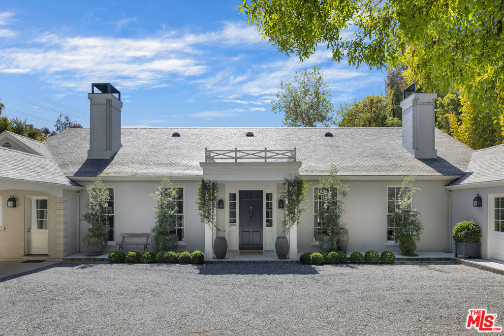 Discover timeless elegance and modern sophistication in this Southern Transitional estate, designed by Windsor Smith. Set on nearly 30,000 square feet of flat, lush grounds, this private sanctuary is hidden behind tall hedges, offering unparalleled privacy and tranquility. As you step inside, reclaimed wood floors and intricate patterned stonework create an immediate sense of warmth and charm. The open, airy living spaces are bathed in natural light, with high ceilings, elegant moldings, and French doors leading to a beautifully landscaped backyard perfect for entertaining or family gatherings. At the heart of the home is a chef's dream kitchen, fully outfitted with double cooktops, double ranges, and a wood-burning oven. A generous center island and cozy breakfast nook overlook the verdant yard, while the adjacent family room, lined with floor-to-ceiling bookshelves, provides a peaceful retreat. The romantic primary suite offers a luxurious escape, complete with his-and-hers bathrooms for ultimate privacy. Thoughtfully designed secondary bedrooms feature charming built-in bunk beds and dormer windows, adding both function and whimsy. Meticulous craftsmanship is evident throughout the home, from the soaring ceilings and custom cabinetry to the exceptional millwork. Outside, the mature landscaping and expansive grounds offer endless possibilities for outdoor activities, gardening, or simply relaxing by the luxurious plunge pool. For the ultimate in entertaining, the newly built guest house features stackable pocket doors for seamless indoor-outdoor flow, a grand entertainment area, a fully equipped gym, a state-of-the-art movie theater, and a temperature-controlled wine cellar. A separate large guest suite and a sunny apartment above the garage provide perfect accommodations for guests or staff. Ensuring the utmost convenience, the home is equipped with advanced water filtration systems, including sediment and carbon block filters, ultra-pure alkaline drinking water systems, and more guaranteeing the highest quality water throughout. This exceptional Brentwood estate offers a rare blend of luxury, privacy, and modern living. Don't miss the opportunity to make this remarkable property your own.