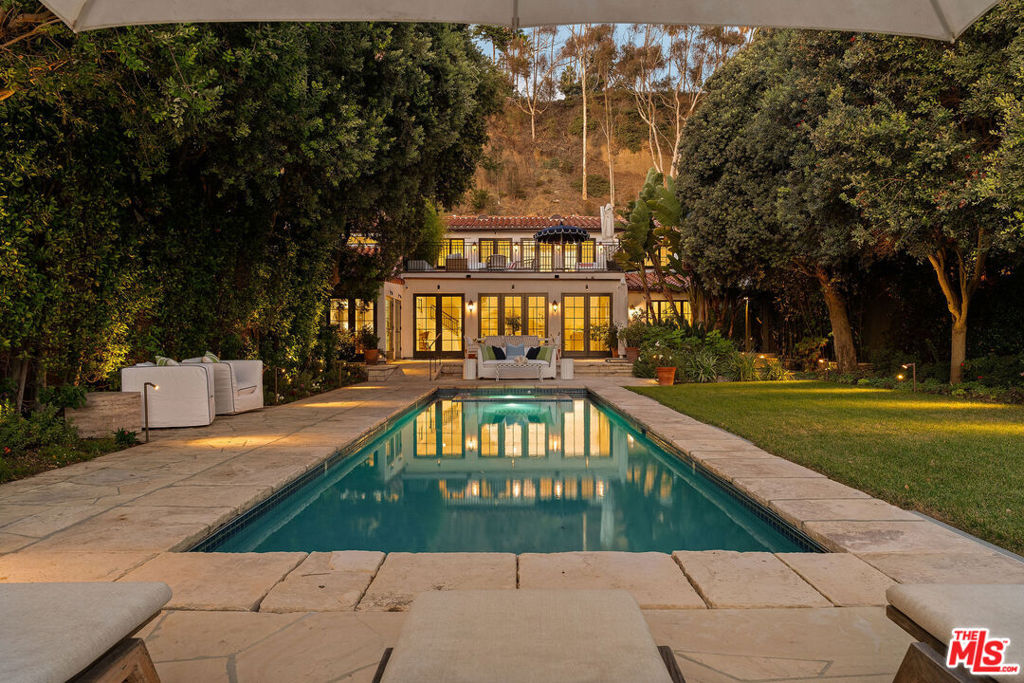 Timeless elegance meets modern coastal luxury in this masterfully reimagined Mediterranean estate. Set on one of the largest oceanfront lots in the area, along Santa Monica's iconic Gold Coast. Once home to Hollywood legend Douglas Fairbanks, this rare property spans roughly 60 feet of coveted beach frontage, uniting rich history with refined contemporary living. Step inside to an airy, sun-splashed living space where ocean breezes flow seamlessly through wide glass doors opening to a private backyard sanctuary. Designed for effortless entertaining and everyday serenity, the outdoor retreat features a sparkling pool and spa, lush green lawn, and multiple areas for dining and lounging beneath the California sky. A full outdoor kitchen complete with built-in grill and wood-fired pizza oven sets the stage for unforgettable gatherings against the backdrop of the Pacific. The chef's kitchen has been artfully redesigned with marble counter tops, premium appliances, including a Wolf range and Sub-Zero refrigerator, complemented by a casual dining nook that invites connection and comfort. There are 2 convenient guest suites located on the main floor, while an elevator ensures easy access to both levels. Upstairs, find another guest suite with a private bath and the stunning primary suite, a tranquil haven with a cozy sitting area, spa-inspired bathroom featuring dual vanities, soaking tub, and walk-in rain shower. Step onto the private ocean-view terrace and take in panoramic coastal vistas and postcard-perfect sunsets. Blending Hollywood heritage with sophisticated seaside living, this re-envisioned oceanfront villa is more than a home it's a rare piece of California's coastal legacy, situated on one of the most substantial beachfront parcels on the Santa Monica coast.
