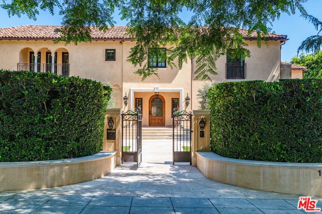 Reimagined in 2016 by architect Richard Manion, "Casa California," a 3-level Italian villa, combines Mediterranean Revival style with Spanish and Italian elements. Commanding over 210 ft. of frontage on Beverly Hills' coveted Roxbury Drive, a gated and hedged entrance framed by arching trees conceals private formal gardens. Rear grounds hold a pool, spa, guesthouse, and fitness studio. Inside, inlaid walnut hardwood guides visitors. A 2-story entry adjoins a living room with fireplace and doors to the front grounds. The library leads to the rear grounds, and a dignified dining room completes the formal areas. Adjacent to the chefs kitchen, a breakfast room and wood-paneled family room open onto the pool. Upstairs is a master suite with custom closets, sitting room, and terrace, and five guest suites. An elevator, entertainment room, bar, and wine cellar complete this timeless, 8-bed, 13-bath compound in the heart of Beverly Hills.