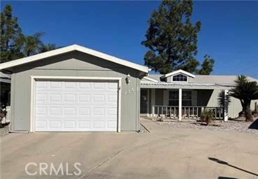 This home located in the desired & gated 55+ senior community of Foothills of Hemet was totally remodeled a few years ago & well cared for so it's like new. Wall to wall luxury vinyl plank flooring. Light & bright kitchen and the third bedroom which doesn't have a door both open up to the living room making the area very open & inviting. Primary and other guest bedroom are spacious. Ceiling fans & newer A/C keep you comfortable all year long. There is also an oversized one car garage (plus extra parking in the front yard which is fantastic) and a breezeway between the primary bedroom & the garage that is great for storage. Easy maintenance yards, and in the back there is a very nice covered patio, The front porch is a lovely place to relax with your morning coffee or enjoy the evening sunsets & breezes. The home itself sits on one of the largest lots in the park, backs up to Commonwealth with gorgeous mountain views and no neighbors behind you. The park is clean, quiet, gated and just plain awesome with amenities including 2 swimming pools, spa, pickleball courts, air-conditioned shuffle board court, exercise room, recreation hall w/kitchen, and rooms to enjoy billiards, cards & crafts. Ask about the park's RV parking area. Commuter friendly, and close to shopping & restaurants. (Resized photos to follow soon.)