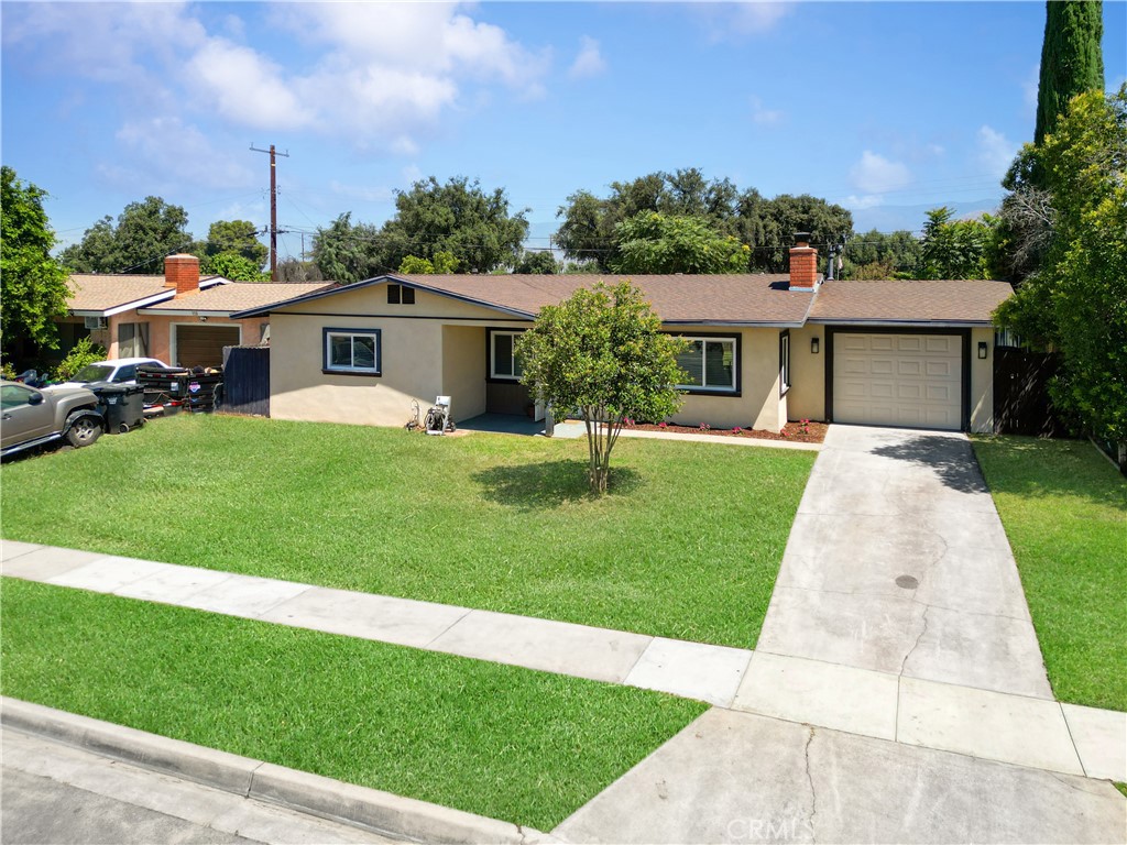 Welcome to 115 Doyle – a true gem in the heart of Redlands! This charming home is centrally located and situated on a large lot with a long driveway for vehicle parking, and great curb appeal, offering endless possibilities. Step inside to find updated tile flooring, a neutral color palette, recessed lighting added to enhance the natural lighting throughout. The remodeled kitchen features upgraded white wooden cabinetry, stainless steel appliances, large farmhouse stainless sink making life easier to entertain and practicality and enhancing the design. There is also a breakfast bar easy access and convenience, and opens seamlessly to the dining and living areas, making it perfect for entertaining. The dining area includes a ceiling fan and sliding glass doors that lead to the spacious back patio, while an additional door provides convenient access to the garage. Enjoy cozy evenings in the spacious inviting living room with its brick fireplace and new windows. The home offers three generously sized bedrooms with plush carpeting. The hall bathroom is beautifully updated with decorative tile, a walk-in shower, and mosaic accents. The primary suite is spacious and boasts its own private, updated bathroom with large vanity, new fixtures and large shower. The backyard is a blank canvas with lush grass and a large, covered patio—ideal for gatherings, barbecues, or simply relaxing outdoors. Don’t miss the opportunity to make this beautifully updated home yours! Home also features: 1 car garage, laundry area, mountain views, newly laid mulch and flowers, room for an ADU or home additions, huge front window, central HVAC system, Ceiling fans throughout, and a home in established neighborhood.