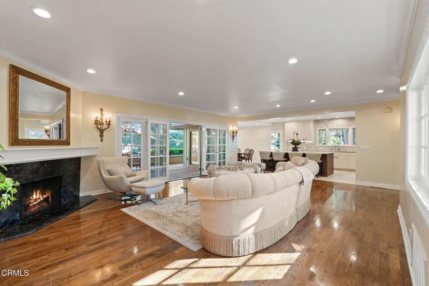 The charm and magic of the Loire Valley await you on a private cul-de-sac in Pasadena's exclusive Busch Gardens neighborhood. Welcome to 1010 Stoneridge Drive, a gorgeous French Provincial home designed for those who appreciate privacy, elegance, and the finer things in life. Tall, lush hedges and century-old Montezuma Cypresses envelop the beautifully landscaped grounds, where afternoon sunlight filters through cascading branches onto the winding pathways crafted from historic Simon's bricks. Coming home feels like entering your own private sanctuary. Crowned with a mansard slate roof, even before you enter it's clear that quality and luxury define this exceptional residence. Inside, the open floor plan creates an ambiance that's both graceful and inviting. The spacious living room, with its gleaming oak floors, handsome fireplace, and wall of French doors flows naturally to the exquisite chef's kitchen, which has been completely remodeled. With commercial grade Viking range, Sub-Zero fridge, and a massive island topped with stunning Taj Mahal quartzite, there's plenty of space to host a charcuterie tasting with a dozen or more guests. Nearby, the open-concept dining room stands ready for the feast to follow and looks out to the peaceful backyard. The home includes three spacious en suites, with two found on the main level. Upstairs, the owner's suite is a peaceful and luxurious retreat complete with a fireplace, garden views, and a palatial bath. Down the hall, find a quiet home office filled with natural light. When entertaining, your supremely private backyard offers the perfect backdrop for garden parties and intimate gatherings with close friends. With lush greenery, a massive outdoor fireplace, and multiple areas to sip, dine, and unwind, time spent here feels like you're relaxing in the French countryside. Just close your eyes, feel the breeze, and listen to the sounds of the songbirds. As part of the historic Busch Gardens estate, the grounds feature remnants of its storied past, including stately decorative volutes and a river rock staircase that once stretched to the back door of the original home, evoking a sense of heritage and timeless elegance. More than just a beautiful home, 1010 Stoneridge Drive is an invitation to savor the good life.