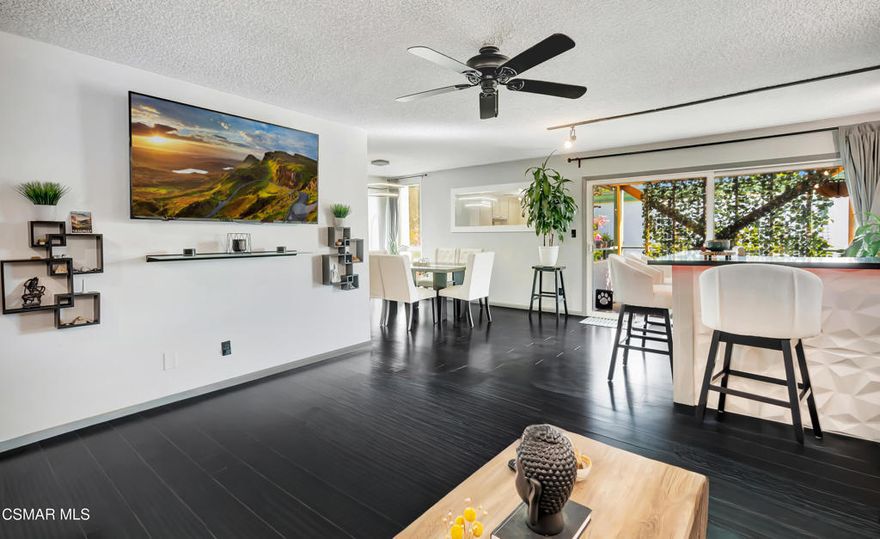 This beautifully updated two-bedroom, two-bath upstairs corner unit offers a perfect blend of comfort, privacy, and modern living in a peaceful garden-style community. Wood-like floors flow seamlessly throughout the home, creating a warm and cohesive feel. The bright and airy living space opens to a private balcony, providing the perfect setting to unwind or enjoy Ventura's coastal breeze.The kitchen connects smoothly with the main living area, and a custom-built bar serves as the home's true centerpiece. Designed for entertaining, it features sleek under lighting, matching bar stools, and a built-in underbar mini fridge--ideal for hosting gatherings or enjoying a quiet evening in style.Additional upgrades include a keyless smart lock, LED lighting, USB-equipped outlets, smart thermostats, and a Samsung SmartThings hub with Google Home displays. The primary bathroom features a floating vanity with a vessel sink, while in-unit laundry offers everyday convenience. A new water heater installed in 2024 provides added peace of mind.As a top-floor corner unit, this home enjoys extra privacy and a quiet atmosphere. One parking space and one garage space are included. The Buena Ventura Gardens community features beautifully maintained grounds, a pool, spa, and clubhouse, and covers water, gas, and a water softening system.The location is exceptionally convenient--just minutes from Cafe Ficelle, Target, Trader Joe's, Ventura College, and Pacific View Mall. With easy freeway access and the beach only a short drive away, this home places the best of Ventura's lifestyle right at your doorstep.