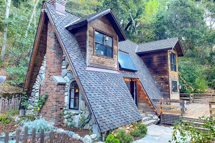 Tucked into 2.5 hillside acres next to Garland Park's Kahn Ranch, this fairytale 2-bedroom, 1-bathroom A-frame cottage blends rustic charm with modern comfort. A stunning stone fireplace, unique pecky cedar, and vaulted ceilings set the warm tone inside, with skylights and an open layout connecting the farmhouse kitchen, dining nook, and living area. Loft-style bedrooms, a separate laundry/mudroom, and thoughtful updates make this home both charming and functional. A lifetime shingle roof adds lasting value and peace of mind. Outside, enjoy an enchanting garden, well-lit driveway, and a freshly graveled parking area. The expansive deck is perfect for outdoor dining, morning sun, or relaxing in a hammock. A newly built private trail leads to mountain views. Just minutes from a seasonal waterfall, creek, and the Village yet secluded enough for true nature lovers this is a peaceful, one-of-a-kind retreat.