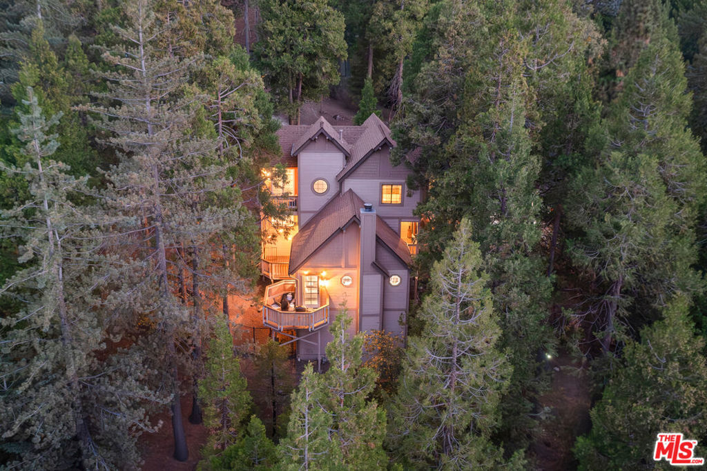 Escape to nature in this bright and inviting 3-bedroom, 2-bath home nestled among the trees in Arrowhead Woods. Set on an expansive double lot offering the utmost privacy and seclusion, this two-level residence features stunning woodland views and three spacious decks perfect for relaxing or entertaining, surrounded by serene forest scenery. The large kitchen provides plenty of space for cooking and gathering, while expansive windows and a cozy fireplace fill the home with warmth and natural light. Each bedroom is generously sized, offering comfort and tranquility, and the primary suite features its own private deck for morning coffee among the pines. Thoughtfully designed with a seamless indoor-outdoor flow, this home invites you to unwind and connect with nature in every season. Enjoy the full Lake Arrowhead lifestyle with LAKE RIGHTS included, as an ideal mountain getaway or peaceful full-time residence.