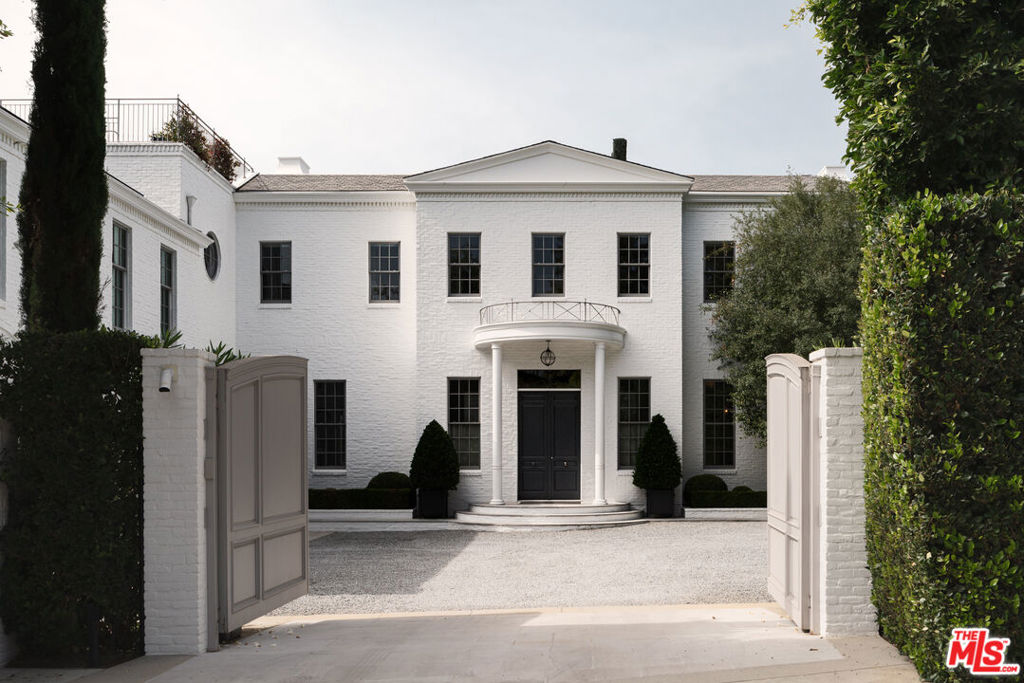 Strategically positioned in one of Brentwood's most coveted neighborhoods, 227 North Tigertail Road is an exceptional gated estate that spans nearly 13,000 square feet. This stunning residence harmoniously blends traditional elegance with a chic contemporary style, crafted by renowned designer Windsor Smith. Pristine interiors feature a sophisticated palette of gray, white, and rich ebony, highlighted by exquisite parquet wood floors and intricate marble accents throughout, alongside soaring ceilings. Arched doorways create a seamless flow between living and entertaining spaces, while floor-to-ceiling French doors and clerestory windows invite natural light and breathtaking outdoor views. The estate showcases a magnificent chef's kitchen and a luxurious primary suite, complete with dual marble showers, a soaking tub, and a cozy fireplace. Surrounded by meticulously manicured lush greenery, the property offers enclosed privacy for a serene lifestyle. Enjoy the rooftop deck for al-fresco dining, a zero-edge swimming pool, a dedicated yoga room, a sauna, and both a detached one-bedroom pool house and an additional one-bedroom pavilion featuring a home theatre. Tigertail is the true embodiment of classically inspired contemporary design, providing an ultra-private sanctuary just minutes to world-class dining, shopping, and entertainment.