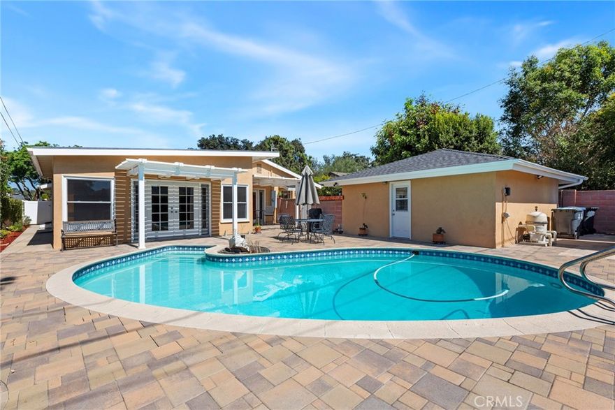 Welcome to this stunning residence in the highly sought-after Floral Park neighborhood of Santa Ana!  Step inside and experience timeless appeal with modern convenience. This beautifully maintained home features original hardwood floors, a spacious open floor plan, and fresh interior paint. The inviting living and dining are enhanced by skylight that fill the space with natural light and a cozy fireplace that adds warmth and elegance. The family room offers a comfortable setting for gatherings, complete with built-in bookcases that add character and functionality. The kitchen, showcasing elegant Caesarstone countertops, premium appliances, slate flooring, and abundant wood cabinetry. The home’s layout provides privacy and comfort, featuring well-appointed bedrooms with window shutters, a Jack-and-Jill bathroom, and a second full bath with bathtub. A convenient laundry area adds practicality to daily living. Additional highlights include central air conditioning for year-round comfort. Step outside to enjoy the best of Southern California living — a low-maintenance backyard with pavers and a sparkling swimming pool, perfect for relaxing or entertaining. The long driveway offers ample parking and leads to a detached two-car garage. Nestled in the heart of Floral Park, one of Santa Ana’s most beautiful and historic neighborhoods, this home is surrounded by tree-lined streets, classic architecture, and a strong sense of community. Enjoy nearby parks, charming cafes, and local events that make this community one of the most desirable places to live.