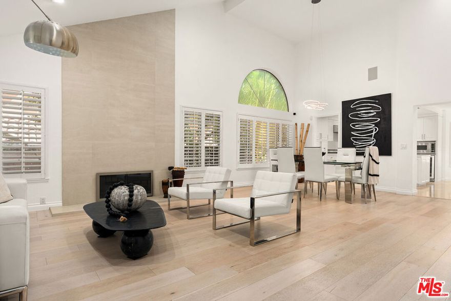 Welcome to Calabasas Hills Estates, an exclusive gated enclave in the heart of Calabasas. 5 minutes from Calabasas Commons shopping and dining, this beautifully upgraded 4-bedroom, 2.5-bath residence offers exceptional privacy, ample parking, and a spacious three-car garage. Set on a flat 12,186 sq ft lot surrounded by mature trees, the home combines timeless style with modern comfort. Impeccably maintained and thoughtfully renovated with premium finishes, the interior is filled with warmth and natural light. Upon entry, you're welcomed into a dramatic two-story living room with soaring ceilings, expansive picture windows, a gorgeous fireplace, and beautiful wood flooring that flows throughout. A stunning staircase serves as the home's centerpiece, while skylights throughout fill the space with soft, natural light. The bright kitchen features Viking appliances, sleek cabinetry, and a large island perfect for both everyday living and entertaining. A second living area adds versatility and additional square footage, complete with its own fireplace and seamless access to the spacious grassy yard and covered patio, ideal for outdoor dining and relaxation. Upstairs, the luxurious primary suite offers a spa-inspired bath, generous closets, a third fireplace, and a large private balcony overlooking the beautifully landscaped backyard. Additional highlights include plantation shutters throughout and a fully paid-off solar power system for exceptional energy efficiency. Ideally located just steps from Bay Laurel Elementary and minutes from The Commons at Calabasas, this light-filled home perfectly balances modern luxury, privacy, and an enviable location within one of Calabasas's most desirable gated communities.