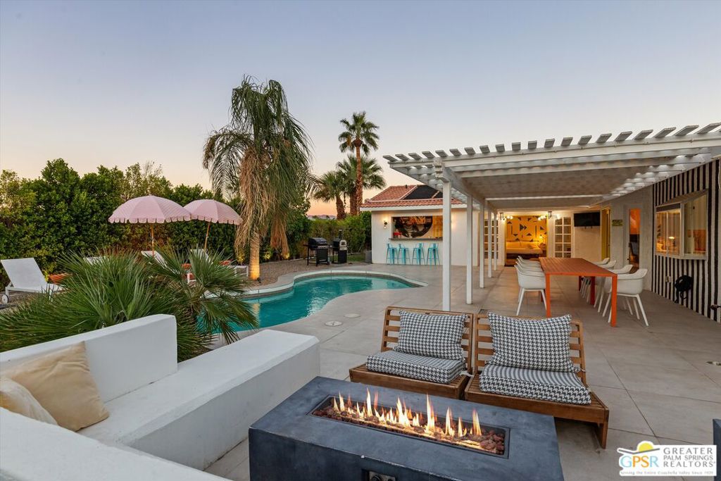 Maximalist Palm Springs Vibes! Offered turnkey furnished, this spacious ranch home has received a glow up to infuse a chill resort style inside and out. Featured in an episode of Staycation on CBS, the designers have created an instagram-worthy home that has operated as a successful vacation rental for several years. Set behind a ficus hedge, the home maximizes recreational use front and back. Interiors are dramatic and include a renovated kitchen with Bosch appliances, soft-close cabinetry, and a striking custom Italian granite slab center island. The dining area includes a service bar with ice maker and beverage cooler. The living area is anchored by custom wall treatments and a gas fireplace. There are three uniquely appointed bedrooms and two bathrooms in the main home, including the resort-size primary which boasts a spacious spa-inspired bathing area, and the suite has French doors opening to the backyard. Rare in this neighborhood, the home has an attached casita with separate entrance, spacious bedroom, generous bath with soaking tub, and a kitchenette with a roll-up window that creates a service bar for the leisure area - perfect for pool party season! Offering a roster of additional service amenities like owned solar, free-form saltwater pool, putting green, hot tub, firepit, BBQ, pizza oven and a 2-car garage currently used as a game room, there's no reason for guests to leave! As of 10.16.2025, there are currently two wait-listed STVR applications for the Gene Autry neighborhood, so realizing this as an investment property can begin immediately with a junior certificate while waiting for a general license. (Buyer to confirm and investigate all details of rental process.)