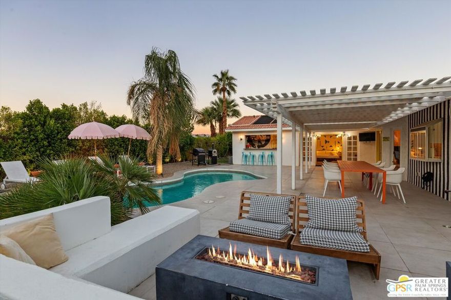 Maximalist Palm Springs Vibes! Offered turnkey furnished, this spacious ranch home has received a glow up to infuse a chill resort style inside and out. Featured in an episode of Staycation on CBS, the designers have created an instagram-worthy home that has operated as a successful vacation rental for several years. Set behind a ficus hedge, the home maximizes recreational use front and back. Interiors are dramatic and include a renovated kitchen with Bosch appliances, soft-close cabinetry, and a striking custom Italian granite slab center island. The dining area includes a service bar with ice maker and beverage cooler. The living area is anchored by custom wall treatments and a gas fireplace. There are three uniquely appointed bedrooms and two bathrooms in the main home, including the resort-size primary which boasts a spacious spa-inspired bathing area, and the suite has French doors opening to the backyard. Rare in this neighborhood, the home has an attached casita with separate entrance, spacious bedroom, generous bath with soaking tub, and a kitchenette with a roll-up window that creates a service bar for the leisure area - perfect for pool party season! Offering a roster of additional service amenities like owned solar, free-form saltwater pool, putting green, hot tub, firepit, BBQ, pizza oven and a 2-car garage currently used as a game room, there's no reason for guests to leave! As of 10.16.2025, there are currently two wait-listed STVR applications for the Gene Autry neighborhood, so realizing this as an investment property can begin immediately with a junior certificate while waiting for a general license. (Buyer to confirm and investigate all details of rental process.)