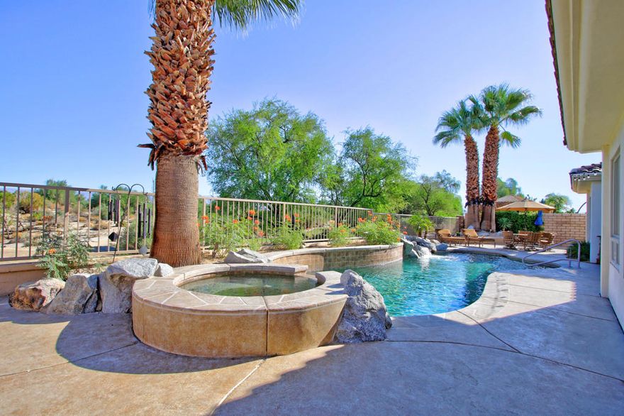 Stunning 4 bed 4.5 bath custom built home. Beautiful designer glass etched double doors lead into the landscaped courtyard. 12 ft. ceilings welcome you into luxury living room with spectacular views of the pool/spa/waterfall/oasis overlooking the Desert Willow golf course  12th tee box as well as sweeping mountain views. This is your desert dream home! Designer hi-end custom cabinetry with roll out shelving and slab granite counter tops & large walk in pantry. All bedrooms have en suite baths. 1 bdrm. on right and 3 on the left. Spacious master suite & master bath Jacuzzi tub + large walk-in. Bedroom on right now used as formal office but could be an in-house Casita with courtyard entrance. Massive family room with gas fireplace opens to pool/spa & outdoor living areas. Formal dining room. Custom window treatments throughout & electric blinds. Here is 3212 Sq ft. of pure luxury. ENERGY EFFICIENT (leased for 17years) SOLAR LEASE is about $153 monthly with 2 newer A/C condensers & a multi speed pool pump. Mature desert landscaping and palm trees with superb curb appeal. Low HOA at $185 per month. A rare find! Furnishings and electronics may be purchased outside of escrow.