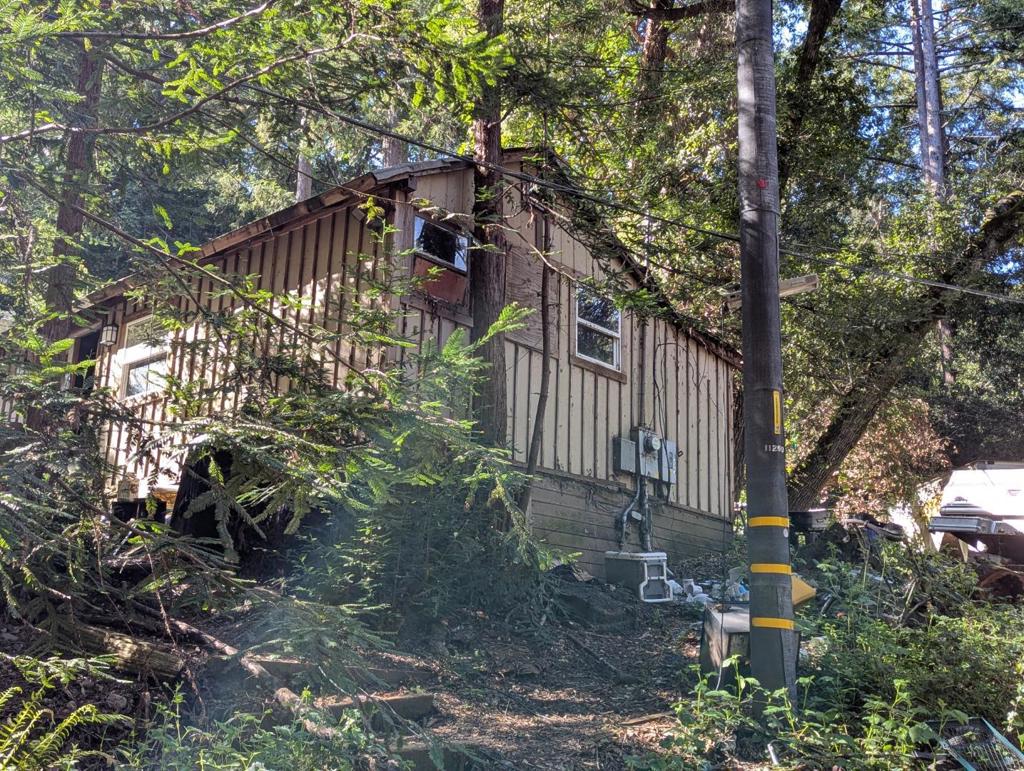 Existing structure will very likely need to be removed; but then you can create your dream home, with end-of-road privacy, on this ~.50 acre property. Though the home is amongst the trees there is a substantial amount of sunlight, and there is plenty of space to garden should you desire. There are an additional 2 lots which may be negotiated separately (~.8 acres and the other ~.5 acres) which feature many Redwoods and a year-round stream. These lots are not buildable pursuant to the County Zoning Department, but would make a great addition to the property and spaces to enjoy outdoors. Loch Lomond is quite near, as is Henry Cowell State Park, and amenities in Felton.