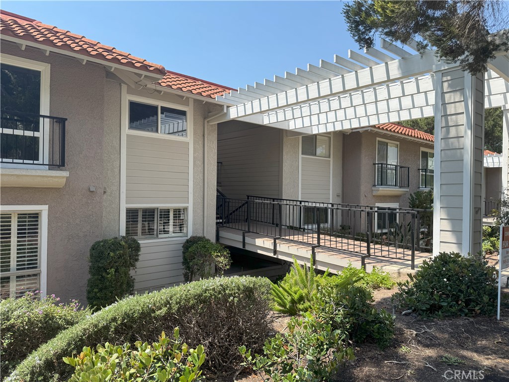 Nestled on a peaceful street, this inviting lower-level 'La Brisa' end unit offers 1,145 square feet of comfortable living space and thoughtful upgrades throughout. Freshly painted with new LED lighting, the home features brand-new carpet and a convenient stackable washer and dryer. The spacious living area includes an upgraded fireplace, perfect for cozy winter evenings, while the kitchen boasts stainless steel appliances—including a large LG refrigerator—for a sleek, modern touch. Both bedrooms offer mirrored closets with generous storage, and the wraparound balcony, accessible from the living room, provides a tranquil retreat overlooking the tree-lined neighborhood—ideal for enjoying your morning coffee or unwinding with afternoon tea. In addition, come and enjoy one of the best 55+ communities in Southern California, close to Laguna Beach, shopping and entertainment centers, has to offer: 24-hr security, 7 clubhouses, 5 pools, 2 fitness centers, 2 golf courses, 10 tennis courts, equestrian center, garden centers, library, performing art center, free bus transportation services, over 200 clubs to join, and much more.
