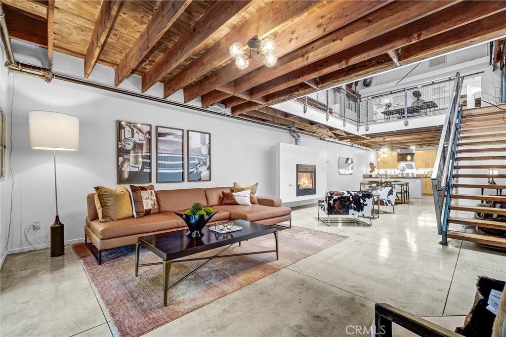 Architectural Loft Living in the Heart of Downtown Long Beach. Welcome to Courtyard Lofts, an award-winning development designed by renowned local architecture firm Studio One Eleven. This boutique community features 16 industrial-style lofts thoughtfully arranged around a tranquil, landscaped courtyard. Recognized with the prestigious 2009 AIA (American Institute of Architects) Housing Award, Courtyard Lofts sets the standard for innovative urban design.Rarely available, this striking two-level residence embodies architectural distinction. Soaring nearly 25-foot open-beam truss ceilings, oversized skylights, and gallery-like proportions fill the space with natural light and dramatic volume. Two private, tree-shaded patios expand the living experience outdoors, while a sleek catwalk and floating fireplace serve as sculptural centerpieces.The open-concept main level seamlessly connects the living, dining, and chef’s kitchen, which is outfitted with premium finishes and fixtures. The well-designed floor plan includes two bathrooms, a generous walk-in closet, and abundant storage throughout—including a spacious two-car garage with additional storage capacity. Upstairs, the airy lofted bedroom suite opens to a private balcony with views—perfect for a peaceful morning or evening retreat. Additional features include polished concrete floors, an in-unit washer and dryer, and central HVAC. Located just steps from Historic Pine Avenue, The Promenade, Shoreline Village, and the beach, this exceptional home offers the very best of sophisticated urban living, wrapped in architectural pedigree and modern comfort.