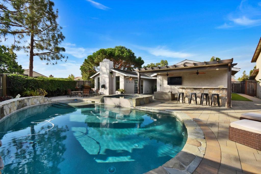 Welcome to 562 Seahorse Lane, a stunning 3-bedroom, 2-bathroom home situated on a sprawling 9,352 sq ft lot in the heart of Redwood Shores. This unique 1,940 sq ft rancher-style residence is perfectly designed for both everyday living and grand-scale entertaining. The thoughtful floorplan features a formal living room, a formal dining room, and a kitchen that flows seamlessly into a cozy family/great room. The kitchen is a chef's delight, boasting stainless steel appliances, including a built-in wine fridge, ready for all your culinary creations. Step outside to discover a backyard oasis primed for your next event. The outdoor kitchen is equipped with an outdoor TV and bartop. Relax under the cabana with outdoor fans and lighting, all overlooking a magnificent pool and hot tub with captivating waterfall features. An elegant built-in fireplace ensures year-round enjoyment. A turfed dog run provides a dedicated space for your furry friends. The primary bedroom offers vaulted ceilings and an en-suite bath with a shower over tub arrangement. A spacious two-car garage with attic access and a large driveway provide ample parking for you and your guests. This home truly is a one-of-a-kind opportunity!