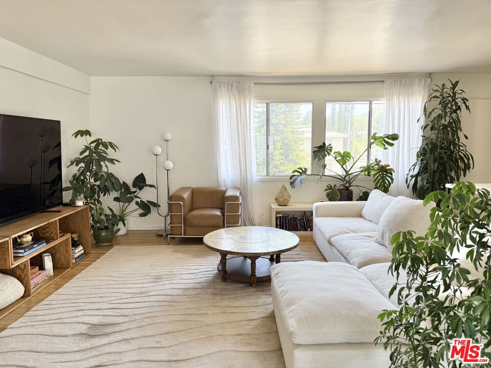 This designer top floor cooperative unit has a brand new kitchen w/ Zellige tile + spa-like bathroom with high end finishes as well as beautifully refinished hardwoods throughout. The recently painted + updated garden style building offers upstairs entry into an oversized living room + dining room drenched in sunlight. A sliding door from your kitchen / dining leads to your private sunny patio. The primary bedroom features dual closets, double pane windows + a gorgeous fireplace facade. The unit comes with one covered carport parking space + private walk-in storage closet. Community amenities include sparkling pool + laundry room. Very central location adjacent to Sherman Oaks. This is a Co-Op and requires board approval of buyer. Please contact us for approved lender. Buyer must occupy the unit and no rentals are allowed.