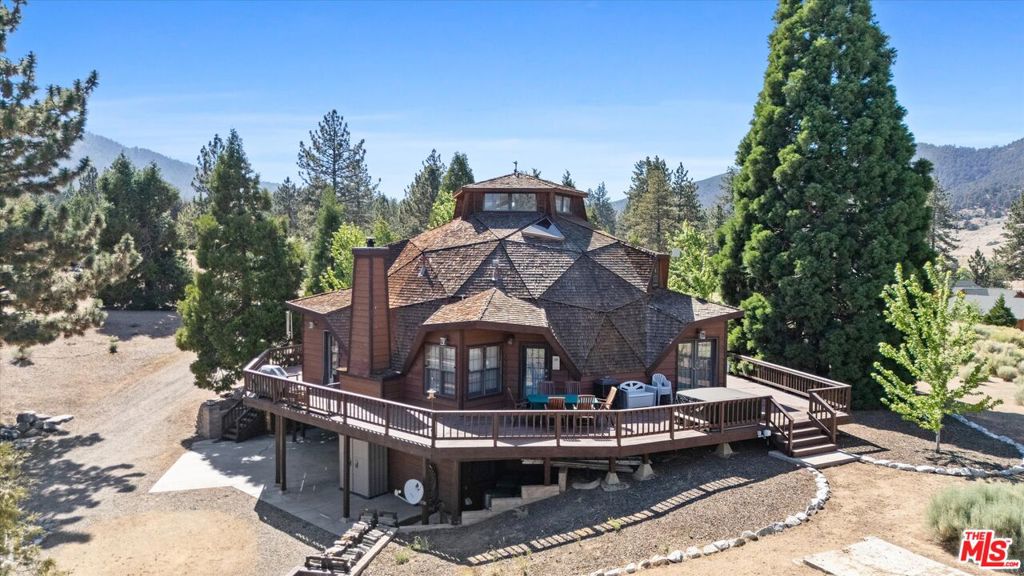 Welcome to The Enchanted Dome - an extraordinary geodesic retreat nestled on 10 fully-irrigated, ultra-private acres in the heart of Cuddy Valley. Surrounded by hundreds of thoughtfully planted trees - including towering Sequoias, Blue Spruce, Cedars, Quaking Aspens, and Pinon Pines - this one-of-a-kind property offers serenity, seclusion, and stunning natural beauty. A mature Sequoia even doubles as a magical natural playground beneath its expansive canopy. The home's architectural brilliance is matched only by its warm and welcoming interior. Enter through stunning double doors, beautifully embellished with glass and embossed detailing, into a grand foyer bathed in natural light. Inside, soaring ceilings, wide-plank oak floors (that run throughout the house!), and clerestory windows create a light-filled, open-concept living space. Three high-end, energy efficient ceiling fans with lights provide tremendous indoor air circulation and aesthetic appeal. The centerpiece is a grand brick fireplace that radiates warmth and charm, with an oversized mantle and wood storage, perfect for cozy gatherings year-round. The updated, eat-in kitchen features brand-new appliances, a custom pantry with granite counters and shelves on both sides, a large bay window, and a gorgeous 100-year-old Glenwood cast iron stove that's as beautiful as it is functional - a true piece of American History. The adjacent den is a true family room with comfy seating and large TV. And, around the corner from the den sits a lovely powder room. The spacious first-floor primary suite includes a wealth of antique furnishings, large, cedar-lined closet, ceiling fan, A/C unit, and private deck access with hot tub. The en-suite bath plays sweet homage to original owner's onsite Christmas Tree business, has doors to outside to enjoy the hot tub or let in fresh air, and includes a wonderful heat light to keep you warm during winter months. Upstairs, a large loft offers versatile space for guests, office, or hobbies, coming complete with trundle bed, sofa bed, antique furniture - and vast, hidden storage. Next to this, a second bedroom includes a cozy sitting nook, leaded-glass interior window, and more clever hidden storage. A skylit full bath completes the upper level. A major bonus is the converted garage - now a recreational paradise featuring a pool table, foosball, infrared sauna, dart board, TV, stereo center, office nook, dining area, and extra fridge. Open the doors and let in the fresh mountain air while entertaining or relaxing! Additional downstairs spaces include a converted bedroom with electric fireplace, a secluded woodshed and storage area, laundry/mudroom with exterior access, and abutting bathroom ideal for cleanup after outdoor adventures. Step outside to enjoy the expansive wraparound decking with space for al fresco dining, morning coffee, or soaking in the hot tub under the stars. The entire property is fenced and features a dedicated fenced enclosure with small animal shed, picnic and seating areas throughout the grounds, large water tank, and 250-gallon propane tank. This turnkey retreat comes fully furnished with a curated mix of antique and modern pieces, hand-selected to complement the home's unique style and history. There's also a complete HVAC system - heating and A/C. Whether you're looking for a full-time residence, weekend getaway, or nature-filled retreat, the The Enchanted Dome offers an unmatched combination of privacy, comfort, character, and mountain charm. More than a home - this is an experience. Come see The Enchanted Dome and fall in love.