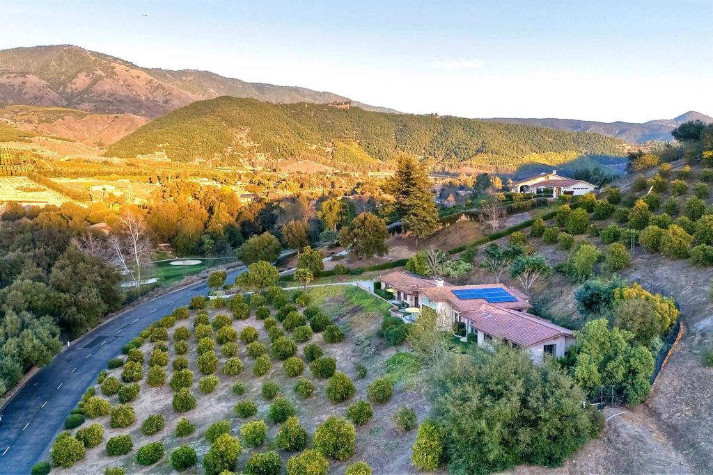 INCREDIBLE SWEEPING VIEWS! You don’t need to look hard to see the tender loving care of this home in the Pauma Valley Country Club Estates has had. Nestled on a hillside setting, you are forever treated to fantastic views of the golf course and surrounding mountains. The occasional plane flying into the private airstrip is a special part of it's views. Most every room has windows/sliding doors, allowing you to enjoy picture perfect natural beauty. The oversized master bedroom has a spacious bathroom. Dual large custom, organized walk-in closets. With an adjoining office and a room that is perfect for a gym or whatever you need. Every cook will enjoy working in the bright, clutter free kitchen with a convenient island. With the support of the kitchen, entertaining is a delight in either the formal dining room or cozy kitchen nook. Both of these rooms offer easy access to a lovely tiled outdoor patio overlooking the valley. Two fireplaces in the living room and den adds to gracious living and keeps you warm on the chilly nights when needed. Besides the two-car garage, there is a space and separate door for a golf cart. Property is 2.53 acres with 2.5 as an orange grove. You don’t know what you are missing until you see the amazing setting and views from this home and Pauma Valley Country Club Estates for yourself. There are three Casino's nearby that offer entertainment, multiple restaurants and spa's. Harrah's Rincon has a Gordon Ramsay Hell's Kitchen restaurant, pool with a separate lazy river. Also, you will enjoy Bates Nut Farm that has year around special events, Farmer's Daughter Boutique and the World Famous Bates Nut Farm store. Here you can get any goodie you can imagine and a section with never before seen gifts for yourself or a special person. The little ones will love the small petting zoo. All in a beautiful rural setting. Pauma Valley Country Club is a private club. New Homeowners are welcomed to apply for Membership. Various Memberships are available.