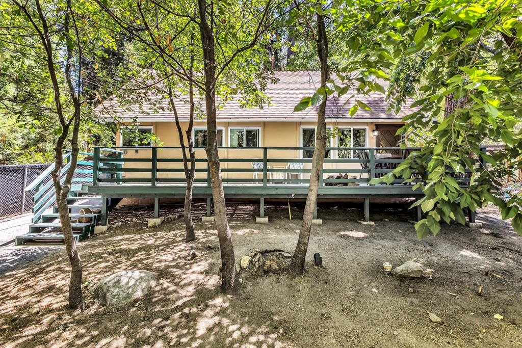 Charming modified A-frame in the heart of Idyllwild, full of potential and mountain character! This cozy retreat features a welcoming living room with a fireplace, laminate flooring throughout, and beautiful tongue and groove ceilings. The main level offers a full bathroom, a private bedroom, and a utility room with washer/dryer and direct access to both the interior and exterior. Upstairs, you'll find a spacious loft, a built-in storage area, a 3/4 bath, and an additional room ideal for guests, an office, or creative space. The fully fenced lot includes an exterior finished room/shed with electricity perfect for a studio or hobby room. Located just minutes from town, hiking trails, and all that Idyllwild has to offer. Come experience the possibilities, schedule your private tour today!