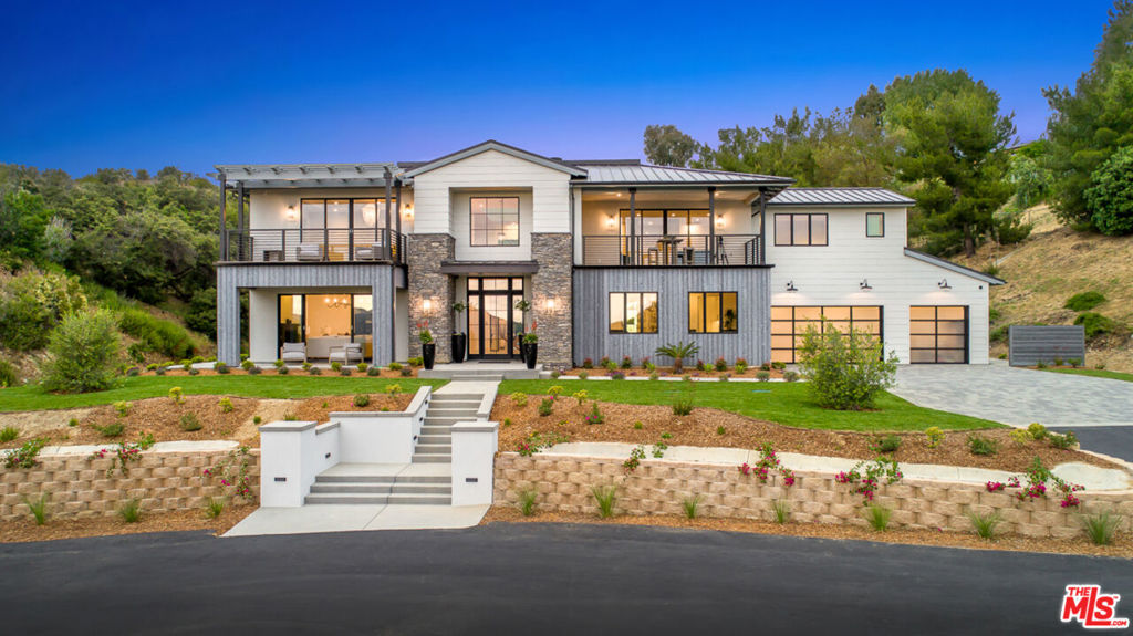 Nestled within the scenic rolling hills of Calabasas, this exquisite modern farmhouse redefines luxury living. Spanning over 2 acres of lush, flourishing land, this estate seamlessly blends contemporary elegance with natural beauty, offering an unforgettable retreat. From the moment you step into the striking foyer, you're captivated by the soaring volume ceilings, an abundance of natural light pouring through expansive windows, and the warmth of wide-plank white oak floors that flow throughout the home. The formal living room exudes sophistication, while the superb office space and inviting great room are anchored by a sleek, modern fireplace. The state-of-the-art kitchen is a chef's dream, boasting top-of-the-line Thermador appliances, a subway tile backsplash, shiplap accent walls, and a butler's pantry that conveniently opens to the outdoors; perfect for effortless year-round al fresco dining. Upstairs, discover three generously sized en-suite bedrooms and a versatile bonus room with an attached balcony. The primary suite is a true sanctuary, offering breathtaking views of the surrounding hills. The spa-inspired master bath features dual walk-in closets, a soaking tub, and a stunning double-sided shower that epitomizes luxury. The rear grounds are an entertainer's paradise, complete with a cabana featuring a private bathroom, an outdoor grill station, and a sparkling pool and spa. Whether hosting gatherings or enjoying quiet evenings under the stars, this property is designed for seamless indoor-outdoor living at its finest. Now also available for lease at $35,000 per month.