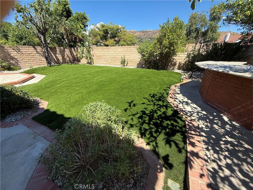 LARGE BACKYARD JUST REDESIGNED WITH LARGE ASTRO TURf AREA, (see pictures).   Remodeled single family home located in the 24 hour guard gated community known as 'The Estates at Porter Ranch'. Front gated courtyard opens to a light and bright floor plan with living/dining room and separate family room, new paint and upgraded carpet. Newer kitchen cabinets, granite countertops and stainless steel appliances with patio views. All bedrooms upstairs. Enjoy the balcony off the master suite. Upgraded baths and more. Don't forget the good sized backyard with, grass, patio, fruit trees and outdoor eating area. Community pools, spa, tennis courts, playground basketball, and more. Nearby large community park, YMCA, Porter Valley Country Club and the almost new "Vineyards shopping mall" with Whole Foods, movie theater and many restaurants.