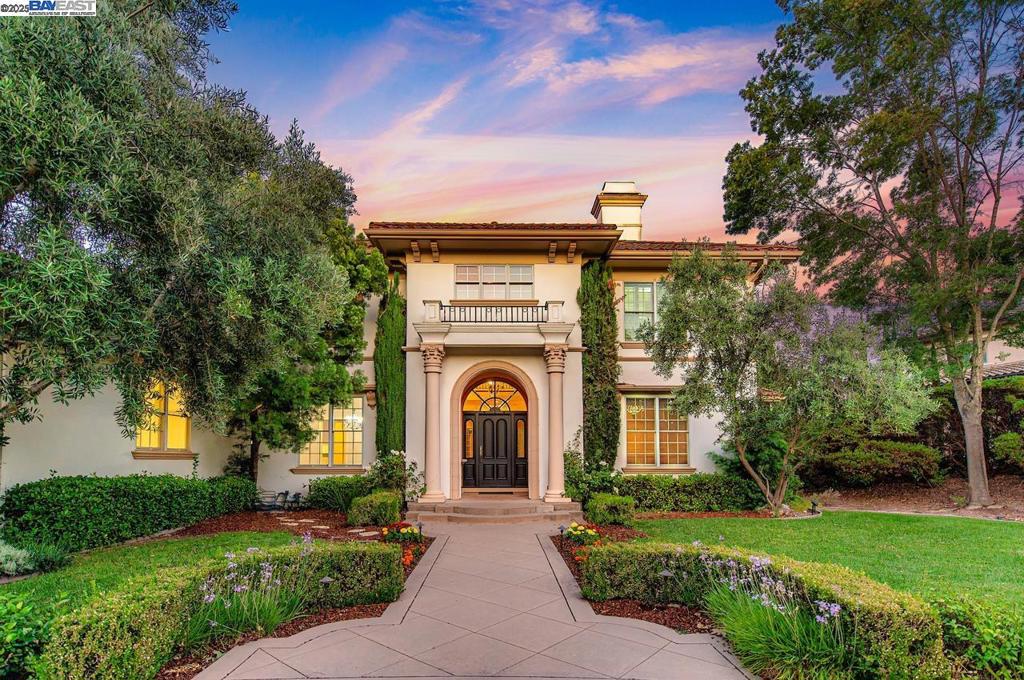 Elegant Italian Villa on a quiet court in gated community of Ruby Hill, sitting on a half-acre lot with a 3-car garage. The dramatic Grand Foyer is flanked by a cherry wood-paneled executive office and formal dining room, with a discreet staircase to the upper level. The formal living room features a fireplace, built-ins, and large picture windows overlooking the backyard. The kitchen includes a large island with vegetable sink and bar seating, Jenn-Air double ovens, gas range, stainless appliances, walk-in and butler’s pantries, plus a built-in desk. The breakfast nook is bright with two walls of windows. The family room showcases exposed wood beams, a raised-hearth fireplace, and sliding glass doors to the backyard. Main-floor bedroom with walk-in closet and nearby full bath with backyard access. Upstairs, the primary suite offers a fireplace, two entries to an exceptional walk-in closet, and an en suite bath with jetted tub, shower with seating, and dual vanities. Two additional bedrooms share a full bath. The backyard has a large patio with pergola, built-in BBQ, and a spacious lawn for a pool or ADU. Enjoy Ruby Hill amenities, top schools, and easy access to major routes, downtown Pleasanton, wineries & Silicon Valley.