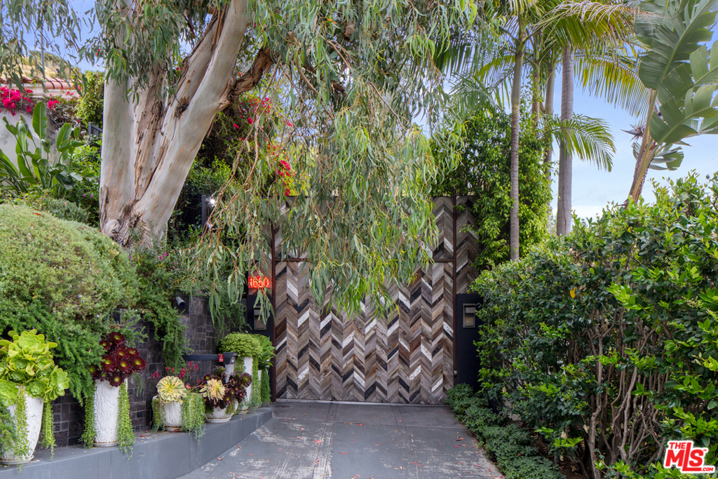 Located behind tall gates at the end of a long private gated driveway in one of the most sought after exclusive locations and best streets in the Hollywood Hills. This extraordinary architectural estate is perfect for those who require the utmost in privacy. Featuring incredible modern design, quality, and craftsmanship. Approximately 5,000 sf set amidst complete privacy and overlooking beautiful city views. Featuring soaring ceilings, great walls for art, incredible indoor and outdoor living perfect for large scale entertaining. Beautiful living room, gourmet kitchen opens to family room, formal dining, bar, theatre, recording studio, gym, and state-of-the-art details. There is an extremely luxurious master suite, stunning guest rooms, an amazing pool, and rooftop deck overlooking the city. Shown to pre-qualified buyers. See private remarks for exclusions.